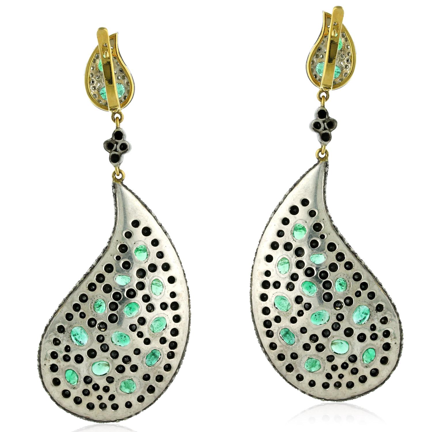 These stunning feather shaped earrings are made from 14k gold and silver, and feature emeralds and pave diamonds. The combination of the rich green emeralds and sparkling diamonds creates a luxurious and sophisticated look. The feather design adds a