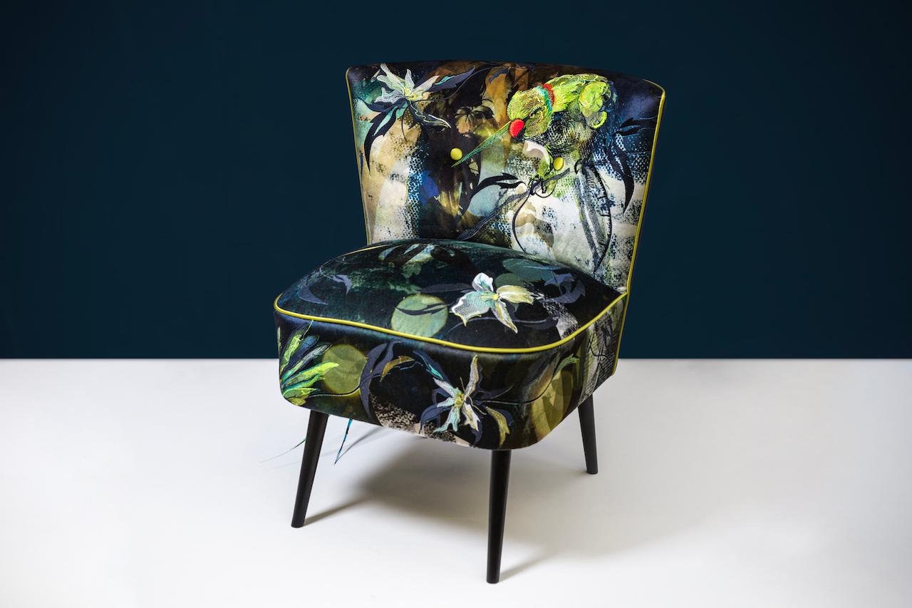 The 'Dandy Parakeets Cocktail Chair' by award-winning, British embroidery artist and designer, Jacky Puzey. This piece is lavishly upholstered with custom-dyed fabric, embroidered velvet and appliqué work. The real feathers add a witty and decadent