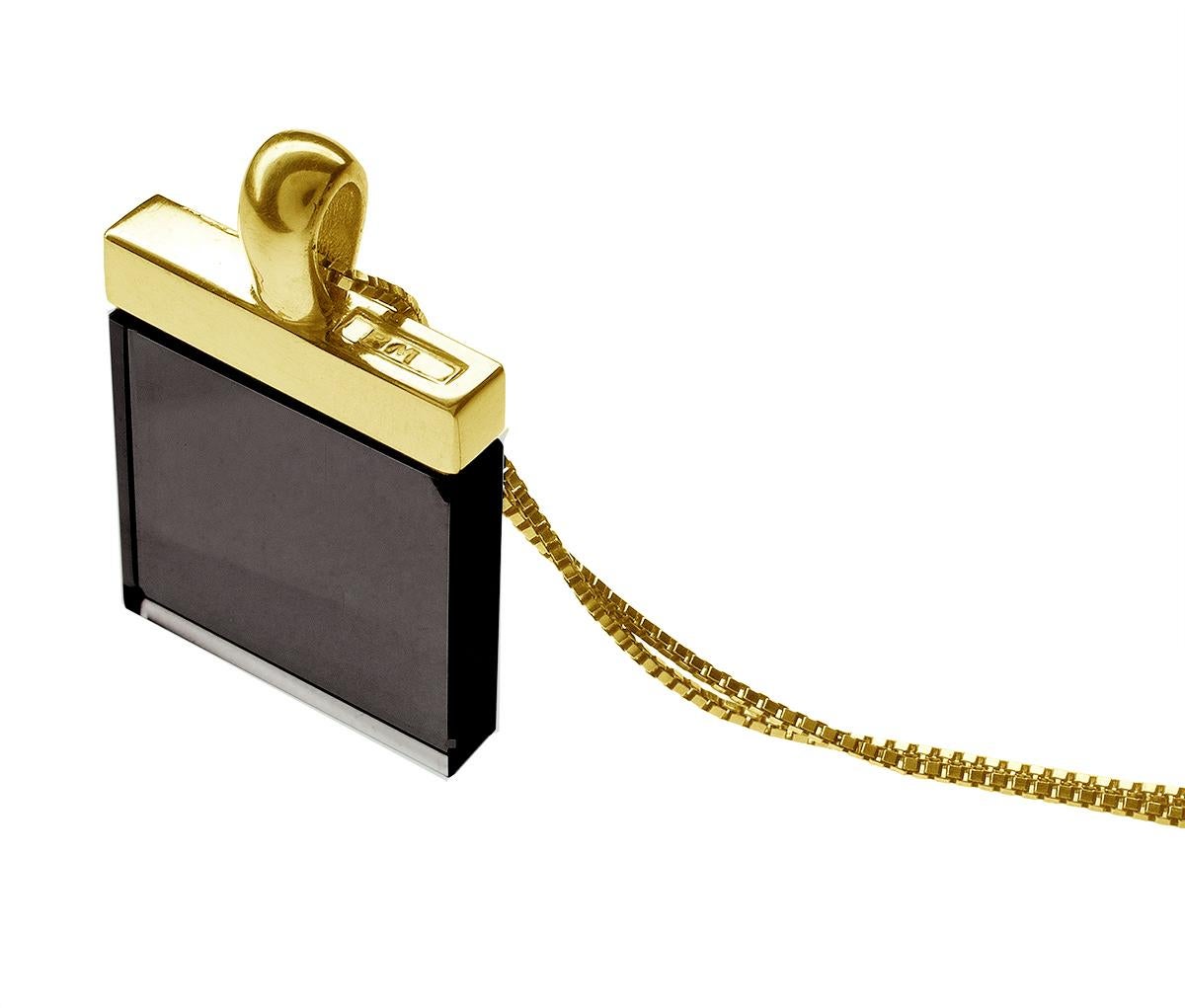 Questa collana con ciondolo della collezione Ink presenta un quarzo fumé incastonato in oro giallo 18 carati. La grande pietra di 15x15x3 mm è tagliata in una forma unica che evoca lo stile art deco, mentre il design complessivo è contemporaneo e