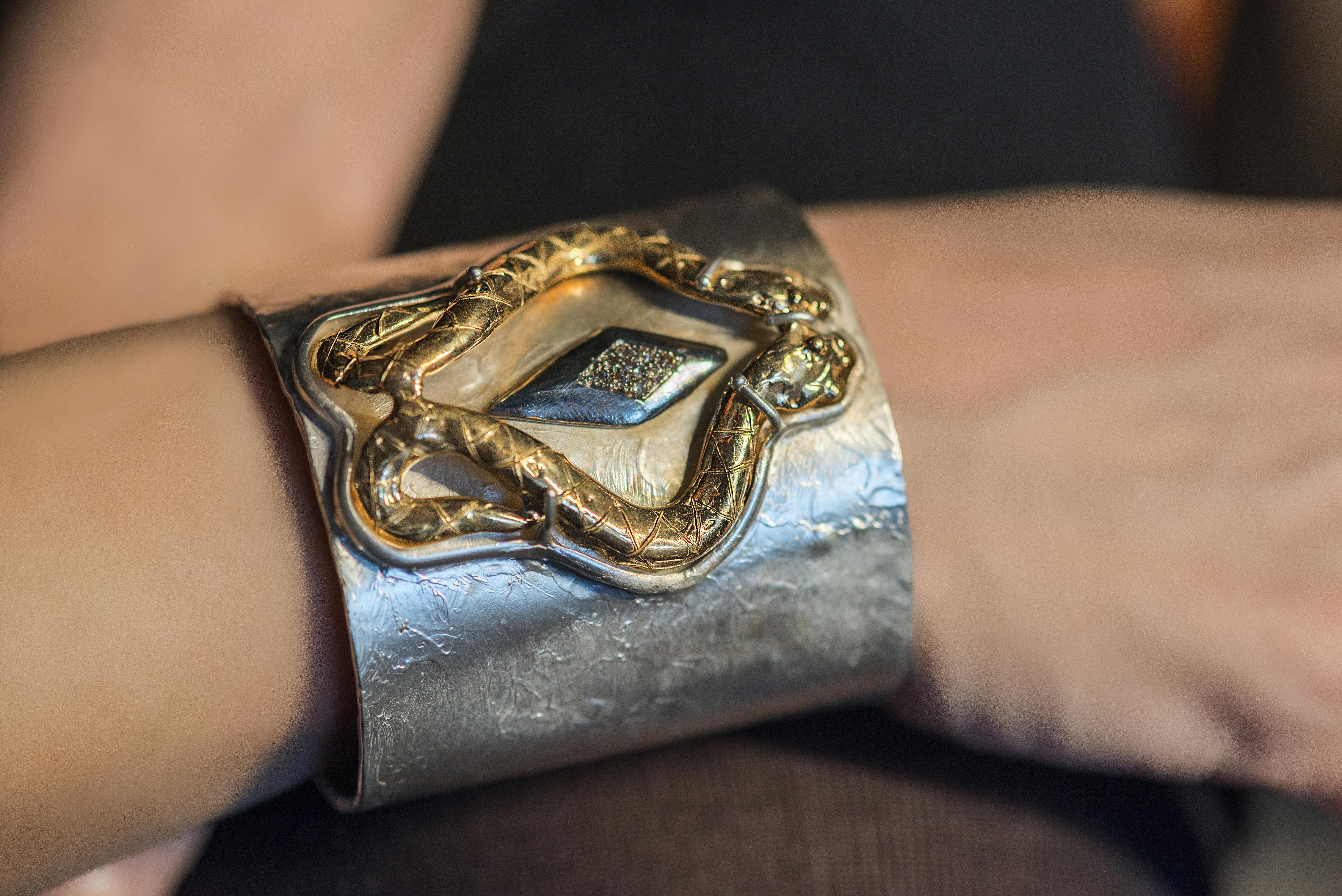 Rossella Ugolini Design Collection  a Fierce Sensual Cuff Snakes Bracelet Handcrafted in 24 Karat Gold Plated Silver Sterling and 0.20 Karat Brown Diamonds.
On the Modern Silver Sterling bracelet two 24 Karats gold plated bronzed snakes meet and by