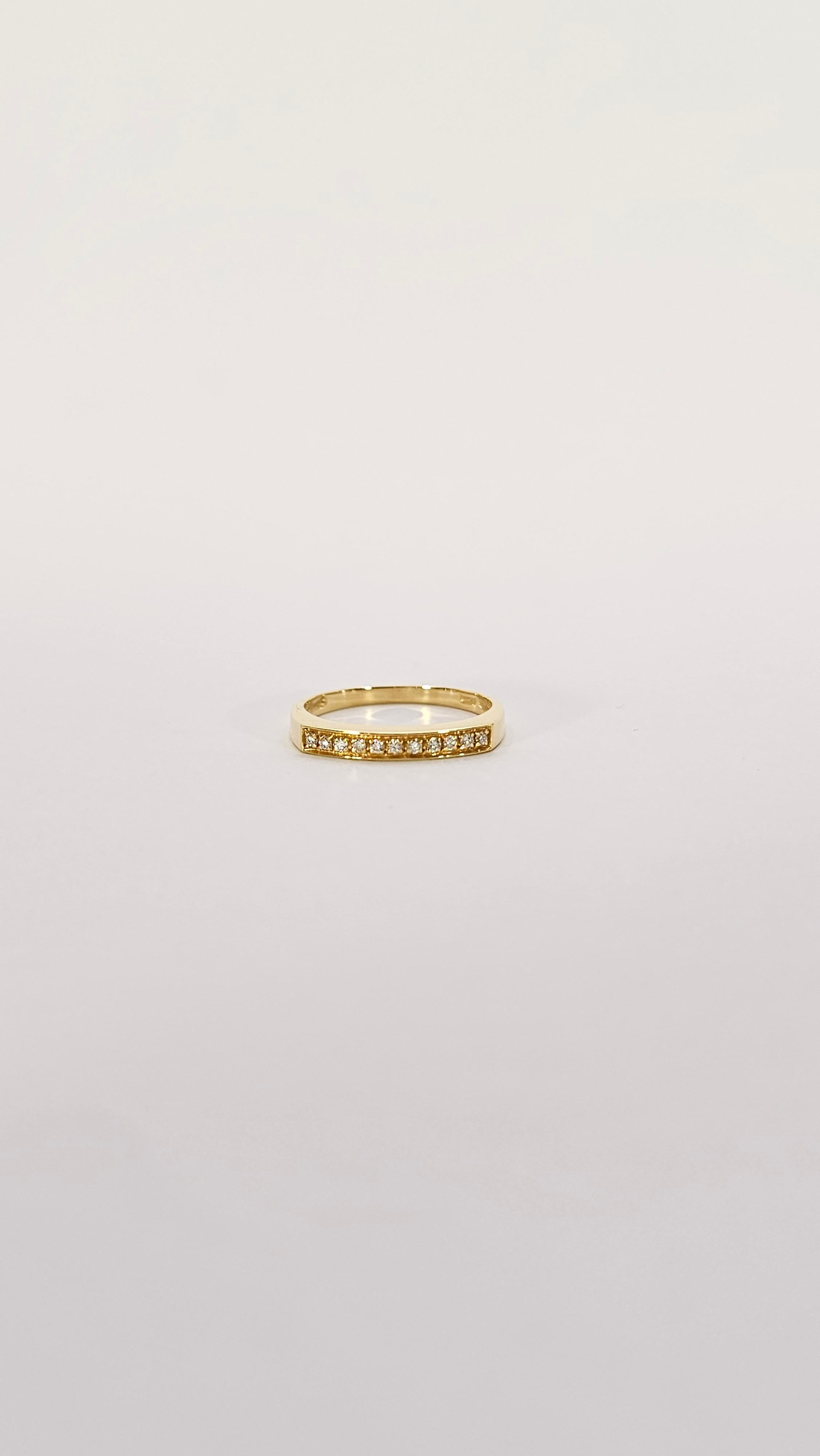 A band ring from the made of 18 kt gold.
Its slightly boxy design on the top harks back to the typical jewelry of the 1970s.
This type of wedding band is perfect for wearing either alone or paired with other wedding bands.
This ring is set with 11