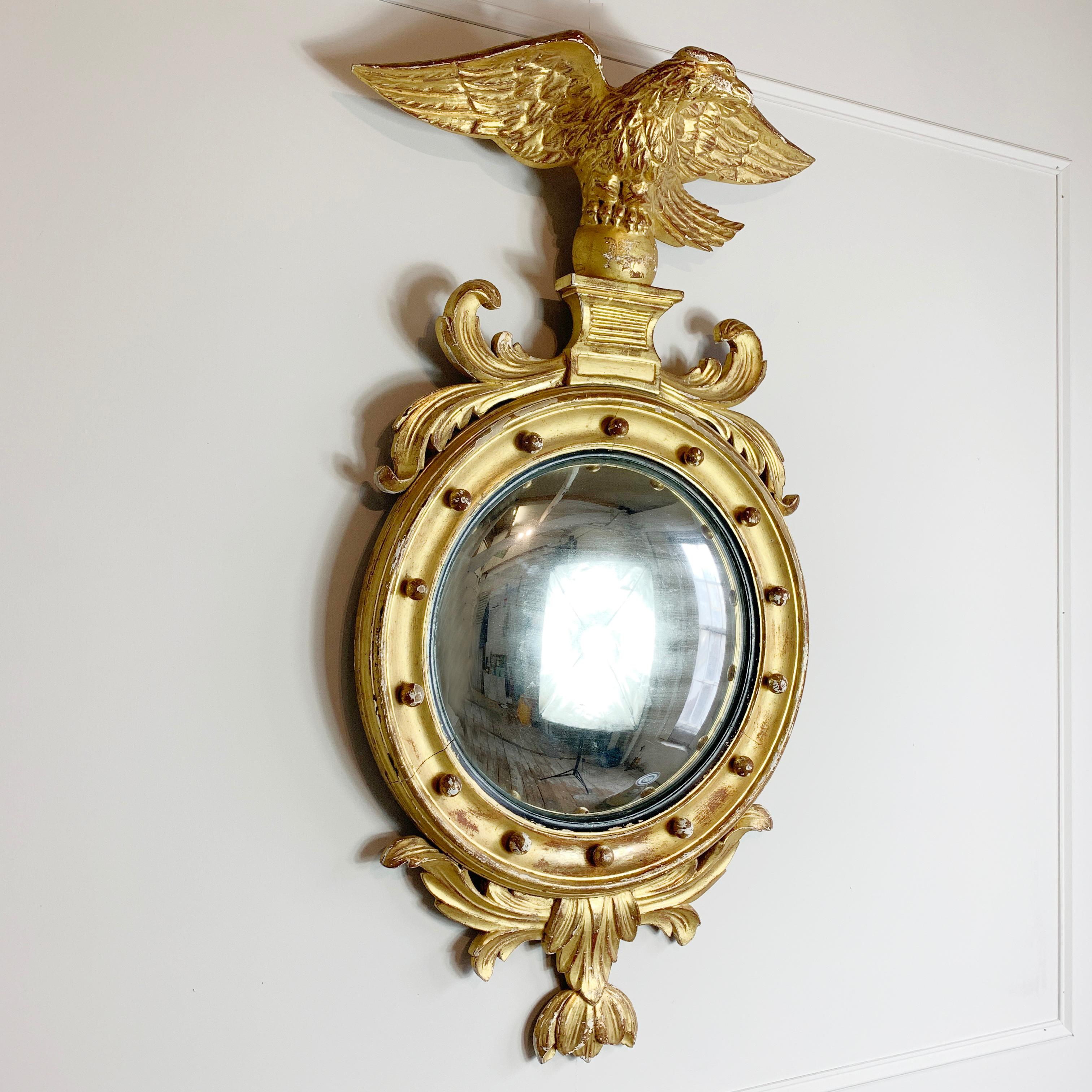Large proportion gilt convex mirror, in the federal style
Dating to circa 1810, English
Adorned with a large carved wooden eagle to the crest, with profuse foliage and acanthus carvings around the convex glass
Wood with gilded Gesso throughout,