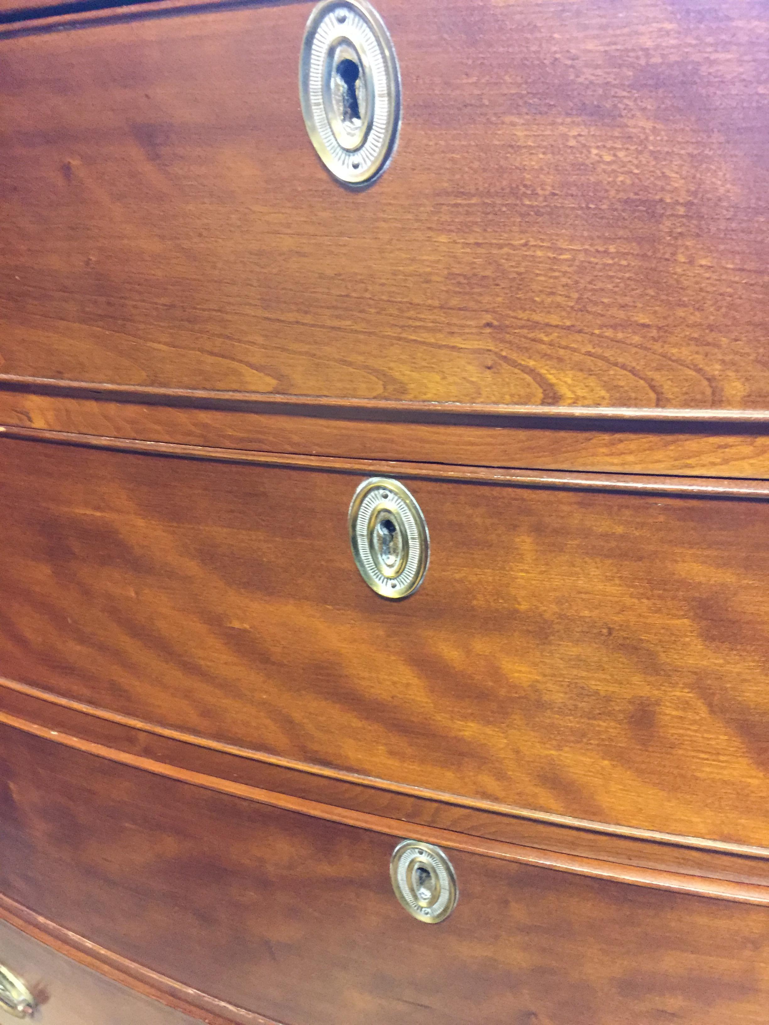 Federal period bow front chest in cherry. Original French feet, beautiful brass escutcheons, excellent color and size, solid top drawer, poplar and white pine interiors. Sturdy, drawers work very well.