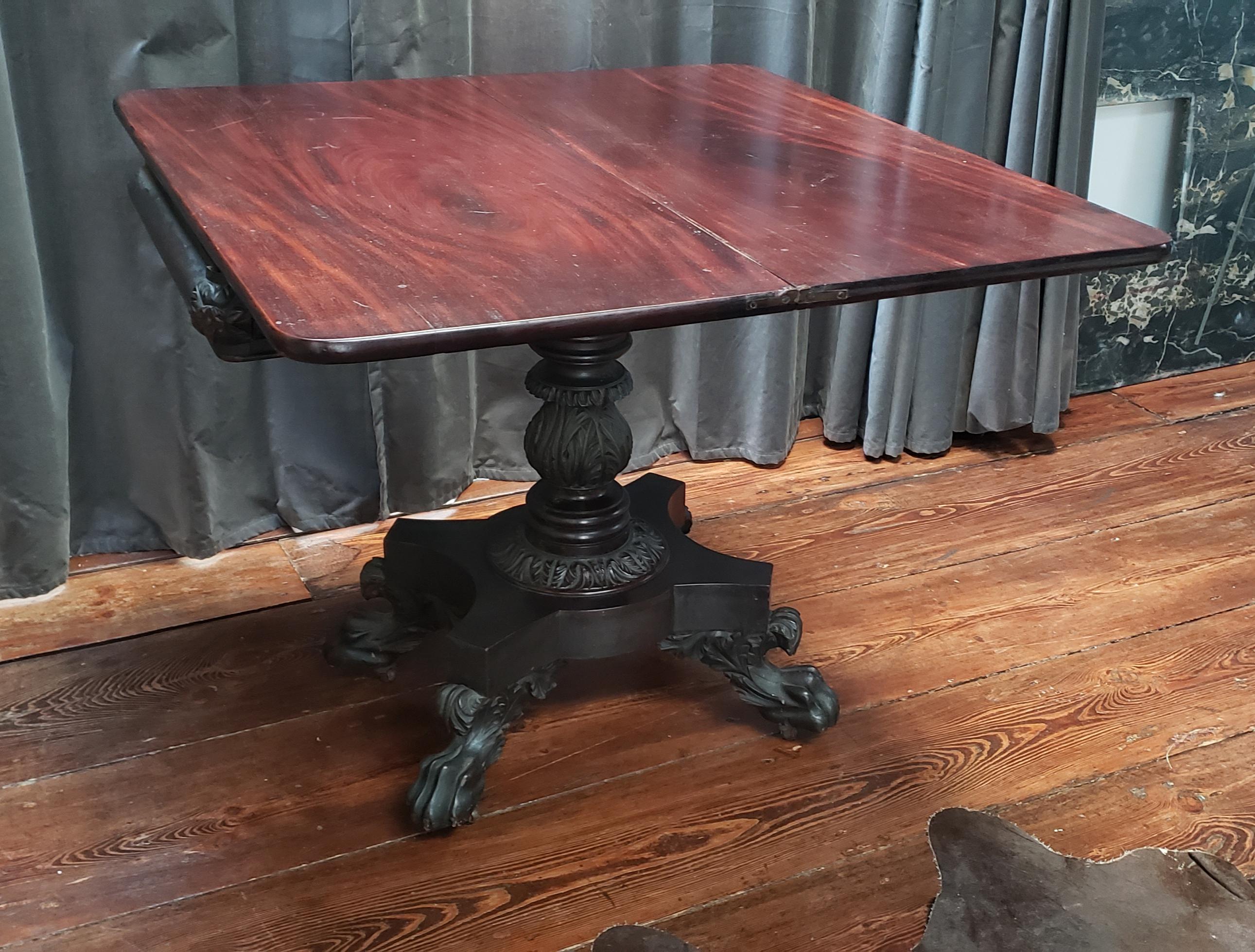 American federal games table in carved mahogany. Flip top with concertina movement. Attributed to the workshop of Philadelphia cabinet maker, Anthony Quervelle, circa 1825. Retains original / old finish and patina.