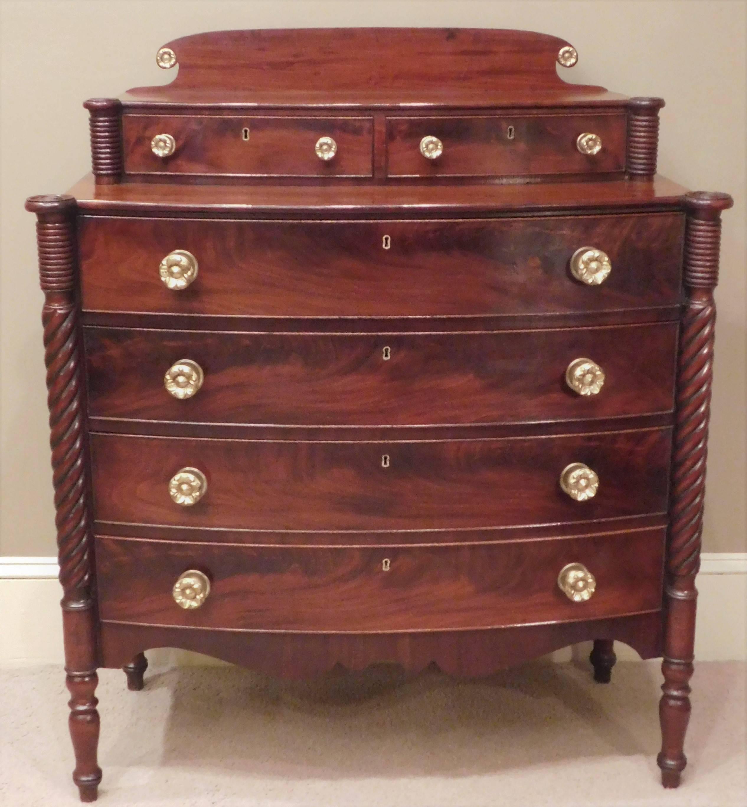 This Sheraton chest is French polished mahogany and mahogany veneer with pine and poplar secondary woods. The hand-cast brass hardware is replaced. The Federal chest has two over four drawers.
 