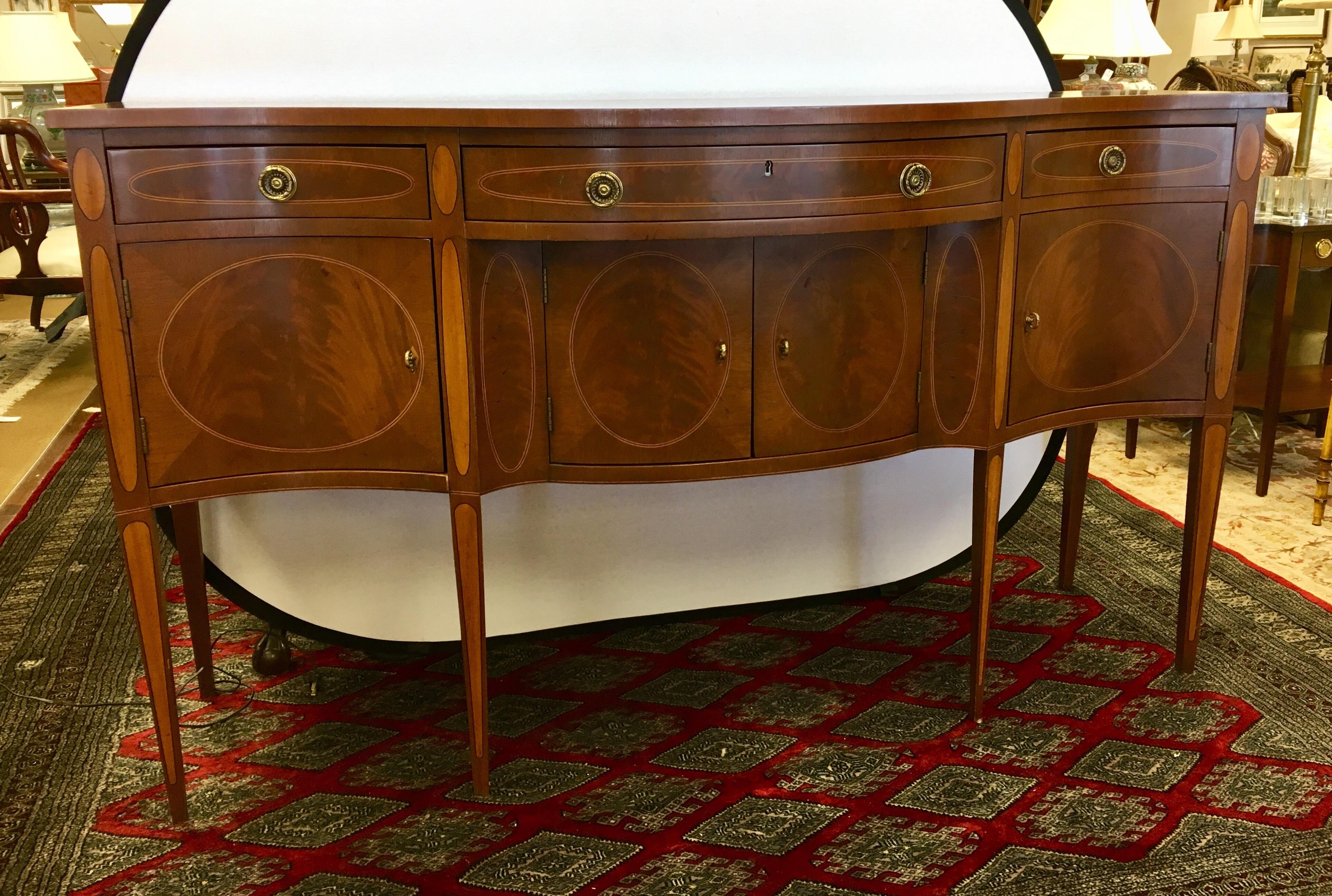 Massive mahogany with inlay throughout server from Hickory White. The buffet's height of forty two inches make it a real statement piece. Features heave brass hardware, multiple drawers and compartments, felt lining for your silver and a bow front.