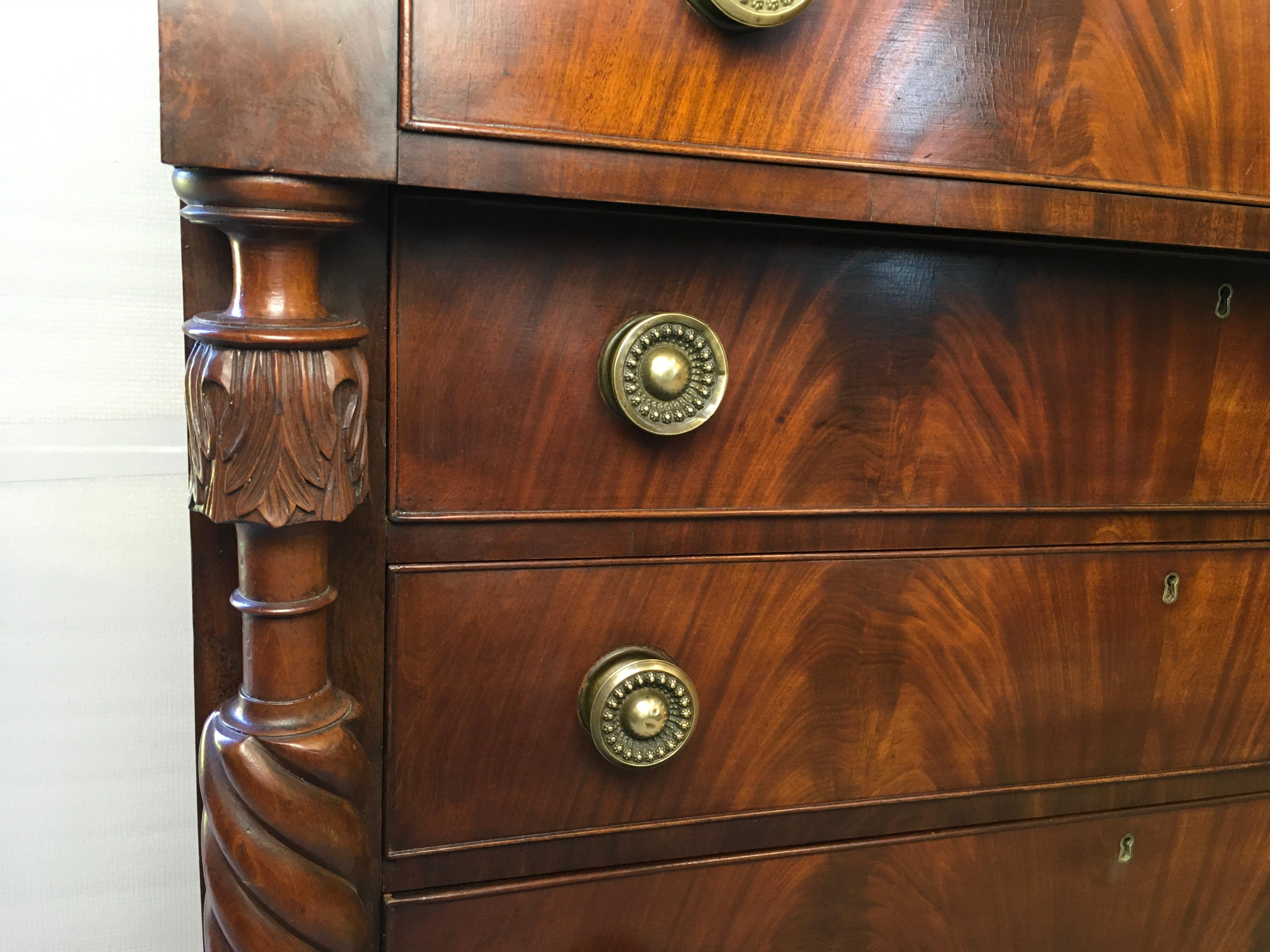 A very nice Federal Mahogany chest 1820-30. This is a really pretty chest with beautiful carved and turned columns on tall turned legs. There is a very nice book matched figured Mahogany veneer on the drawer fronts. The case wood is made of solid