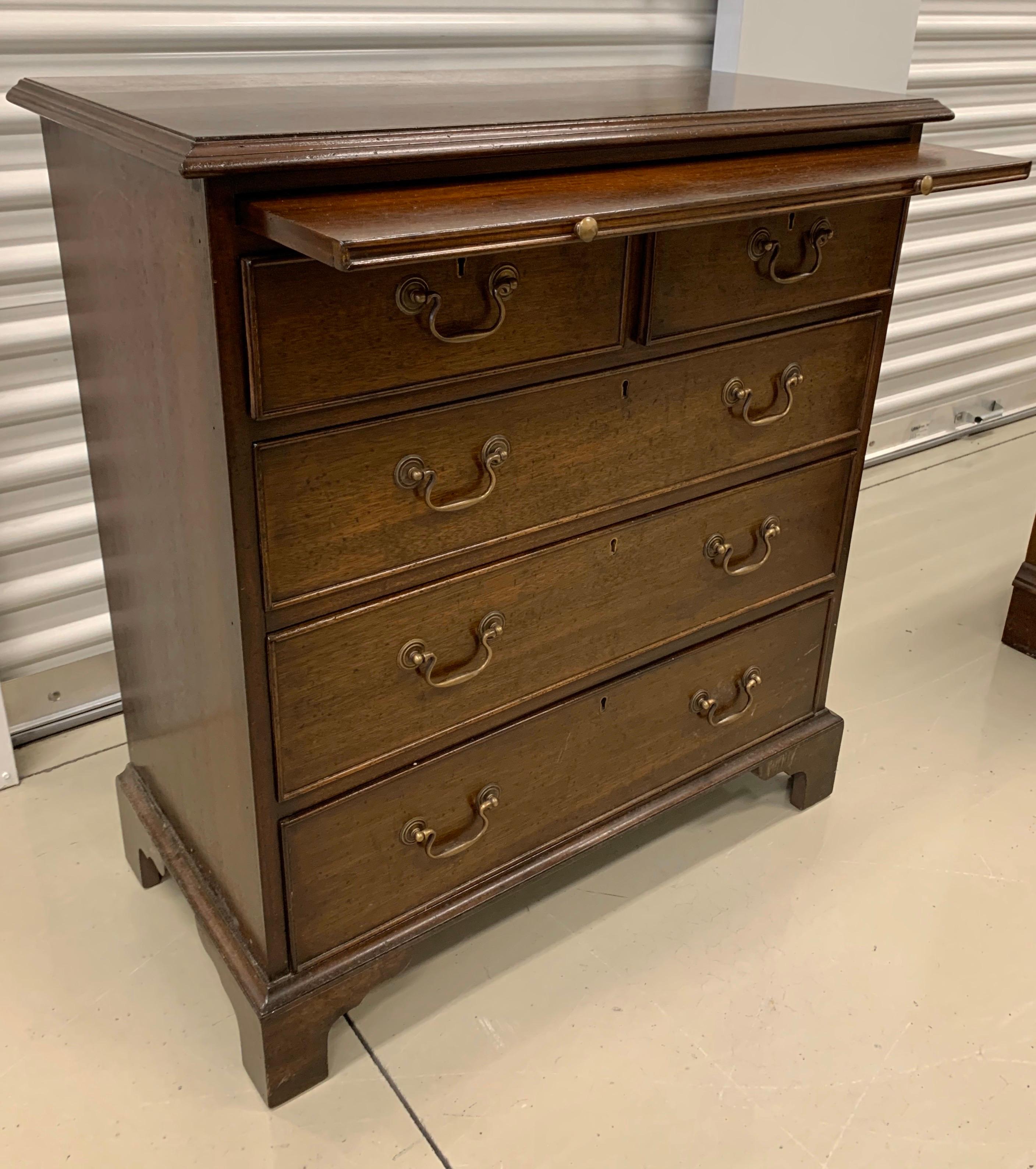 Elegant five-drawer mahogany Federal style commode with an unusual slide out shelf at top that can function as a desk if you so wish.