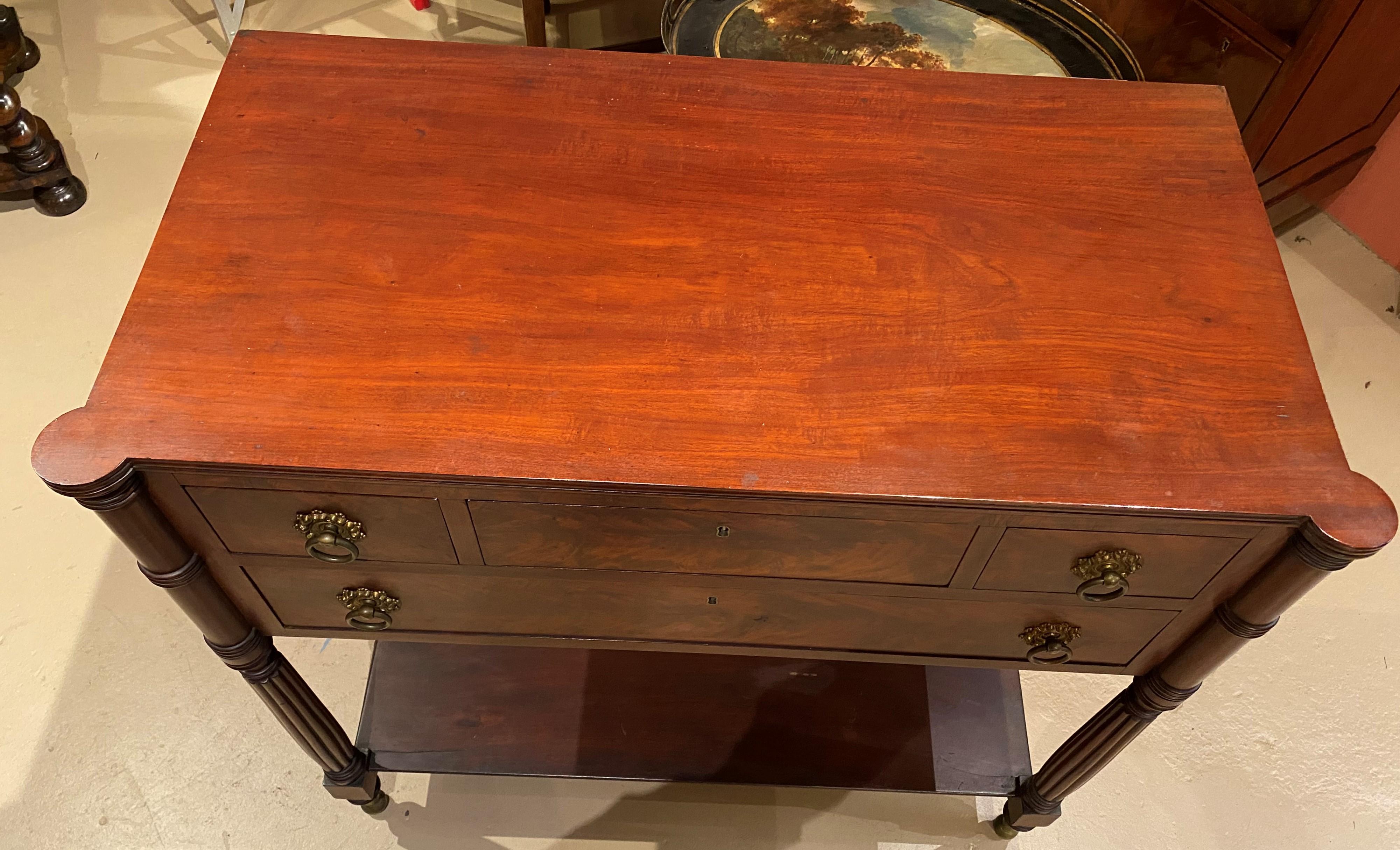 A fine Federal mahogany server with rectangular top with front turret corners surmounting a case with three fitted drawers over one long drawer, brass ring pulls, reeded front legs terminating with brass capped feet, and turned rear legs with a