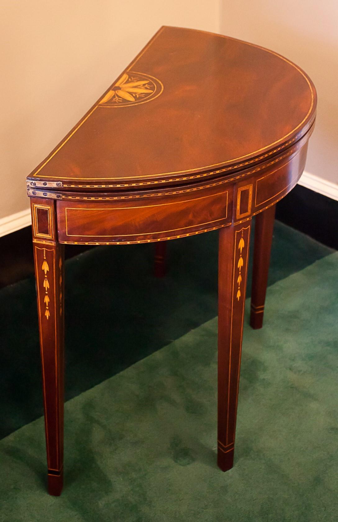 The exceptional bell flowers on the legs of this card/game table lead us to the conclusion that it is probably the work of Baltimore cabinet maker Levin Tarr (1772-1821). The table is mahogany with satinwood, ebony, and boxwood inlay and pine
