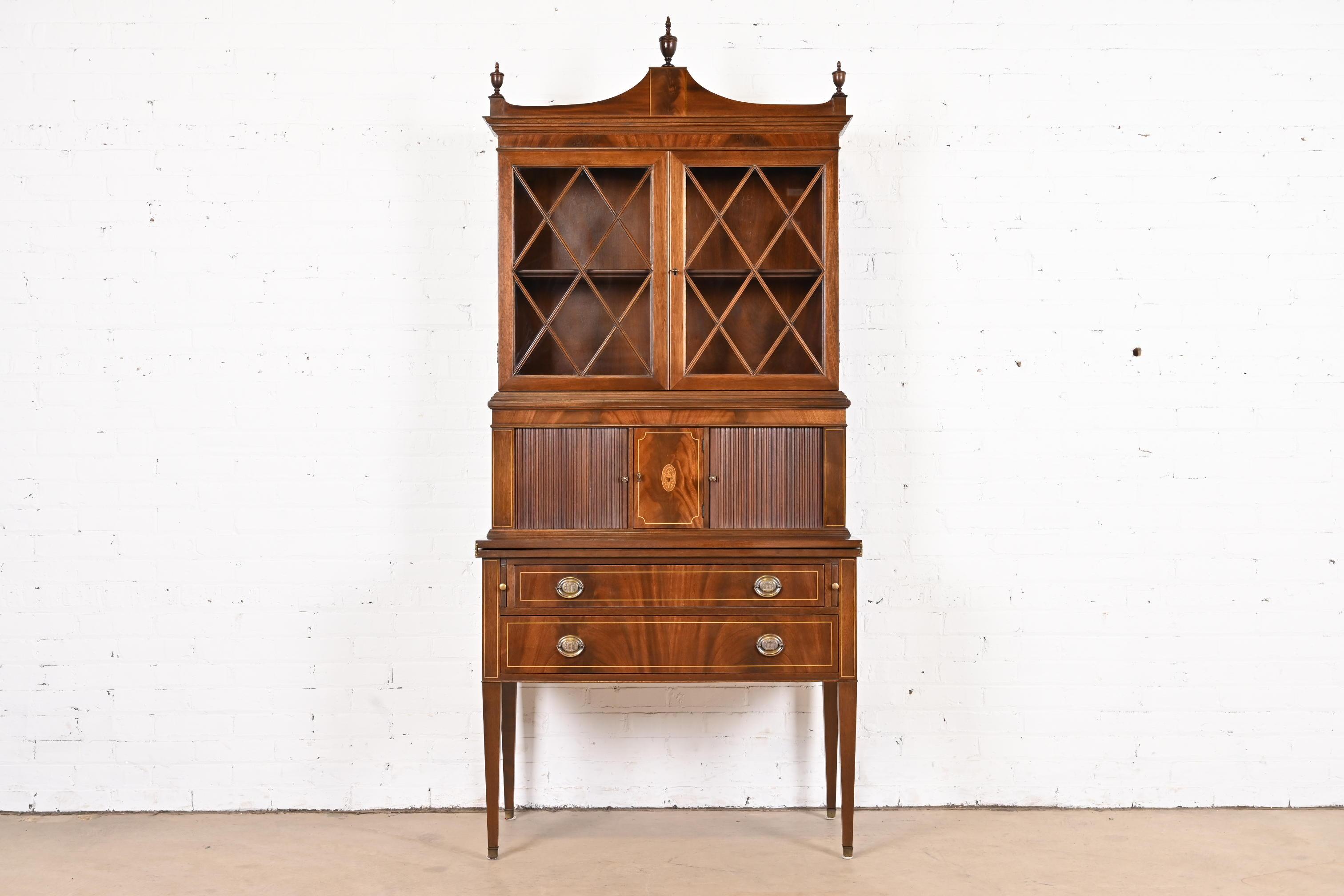 A beautiful Federal style bureau with tambour doors, fold-out desk, and bookcase hutch top

Attributed to Imperial Furniture of Grand Rapids

USA, circa 1940s

Carved flame mahogany, with satinwood inlay and marquetry, original brass hardware,