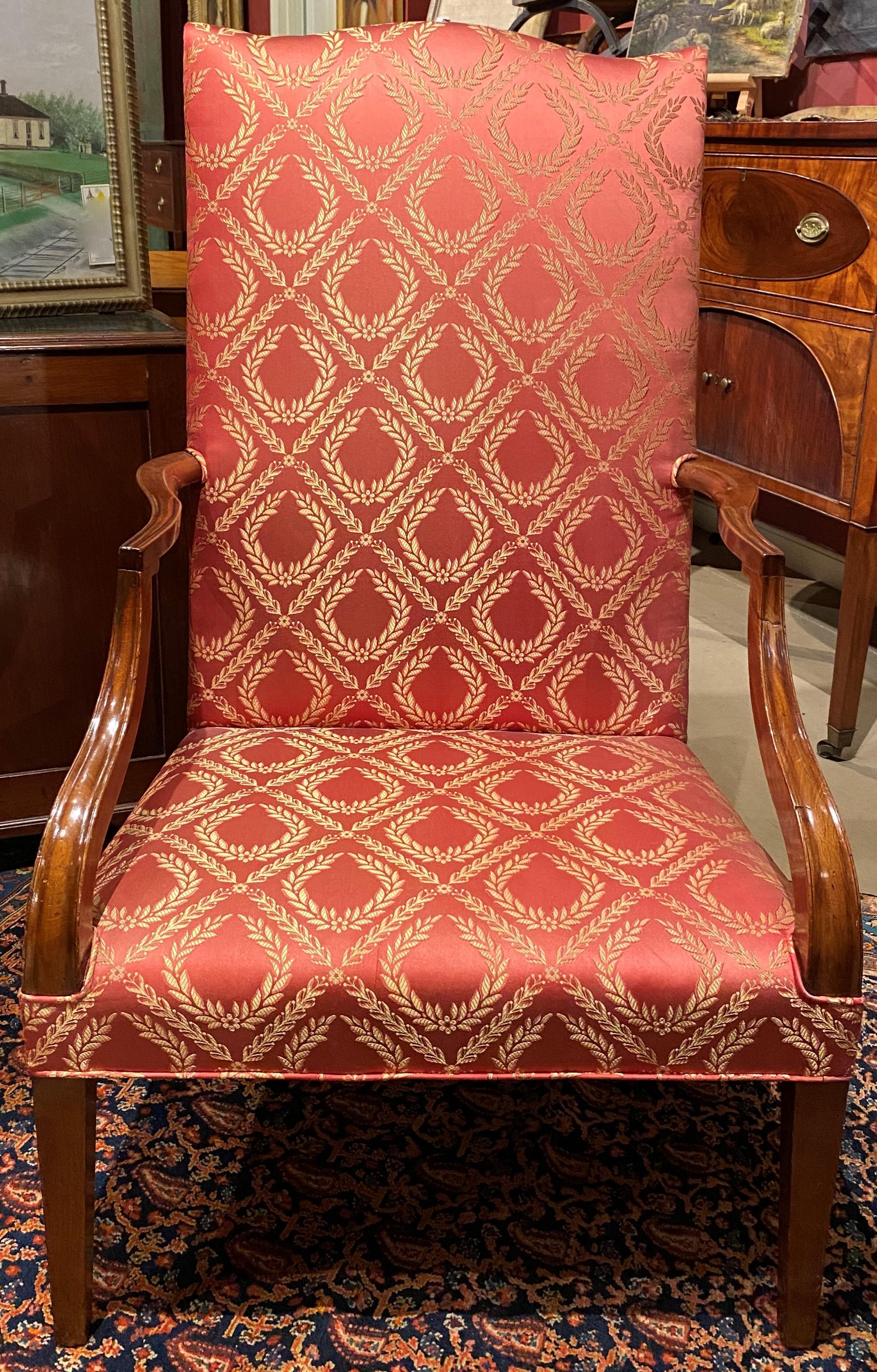 A fine Federal mahogany lolling chair with fresh red satin upholstery featuring gold wheat accent pattern, circa 1785. Provenance: Bernard & S. Dean Levy, New York. Very good overall condition, with minor arm repairs and light overall wear