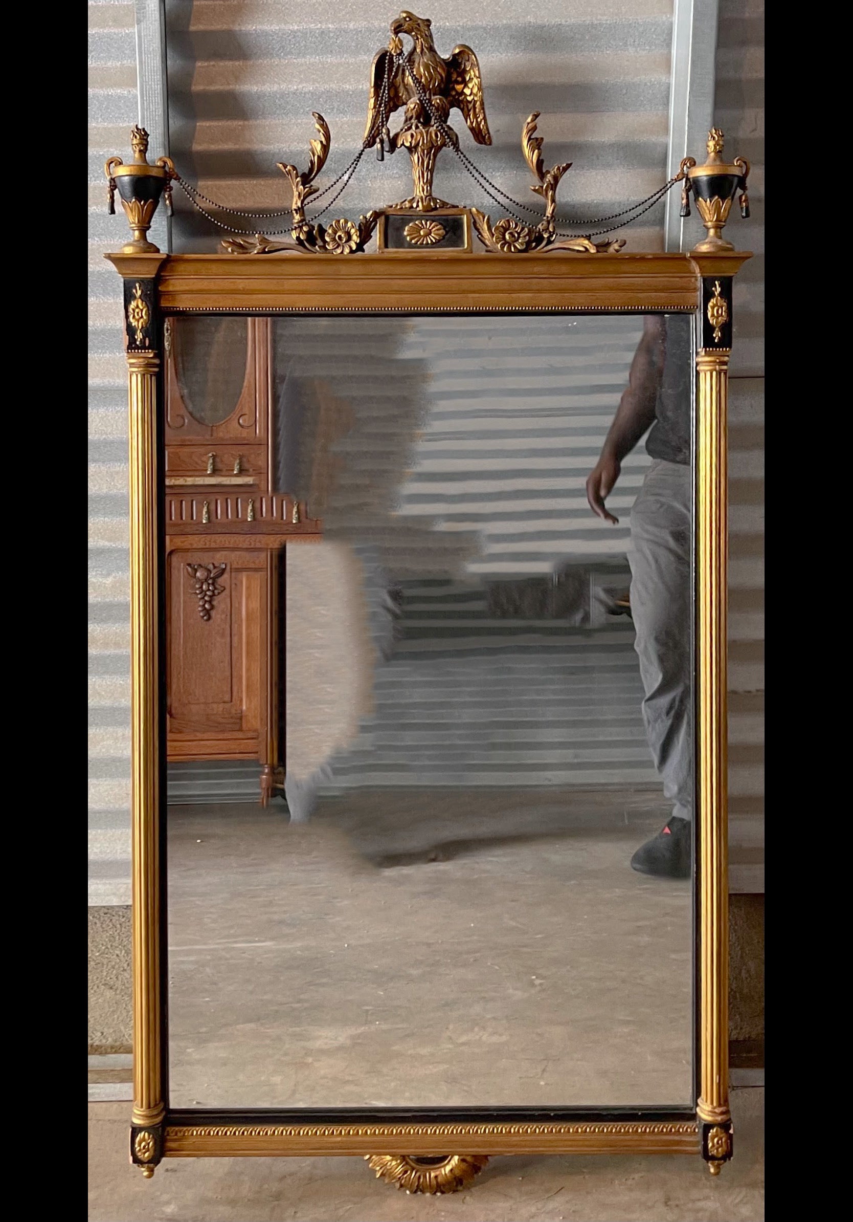 Wonderful mirror! This is a carved giltwood Italian mirror with dual urns and eagle appointments. It is in very good condition and unmarked. It dates approximately to the 50s. 