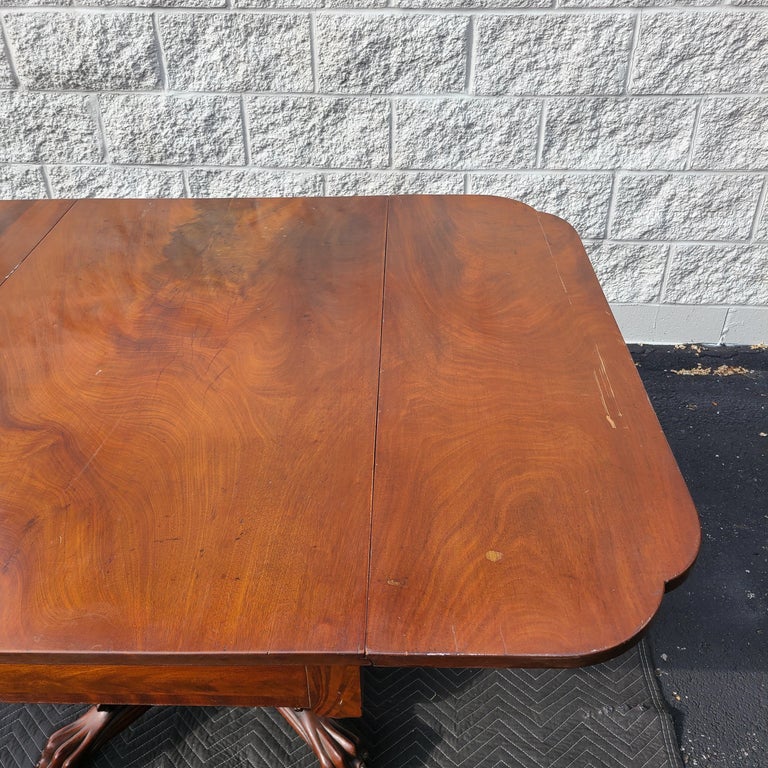 Please message us for a cost effective shipping quote to your location.

Lovely Federal Period mahogany drop-leaf table with carved hairy knee pedestal base. Original condition. Blacksmith made metal features including specific fastener sized