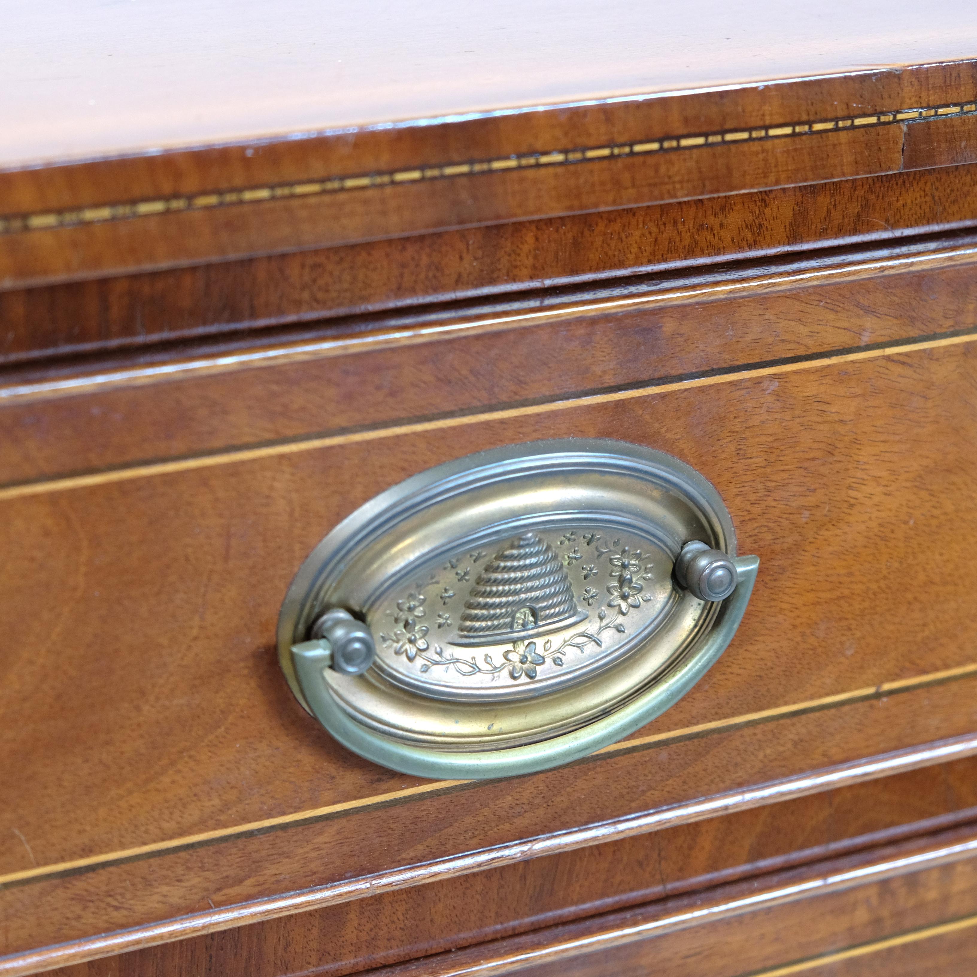 A smart federal period American chest of drawers in mahogany. The top with chequer strung edges, the four graduated and cockbeaded drawers all with later twin brass swing handles on backplates with repousse beehives, all above splayed front legs and