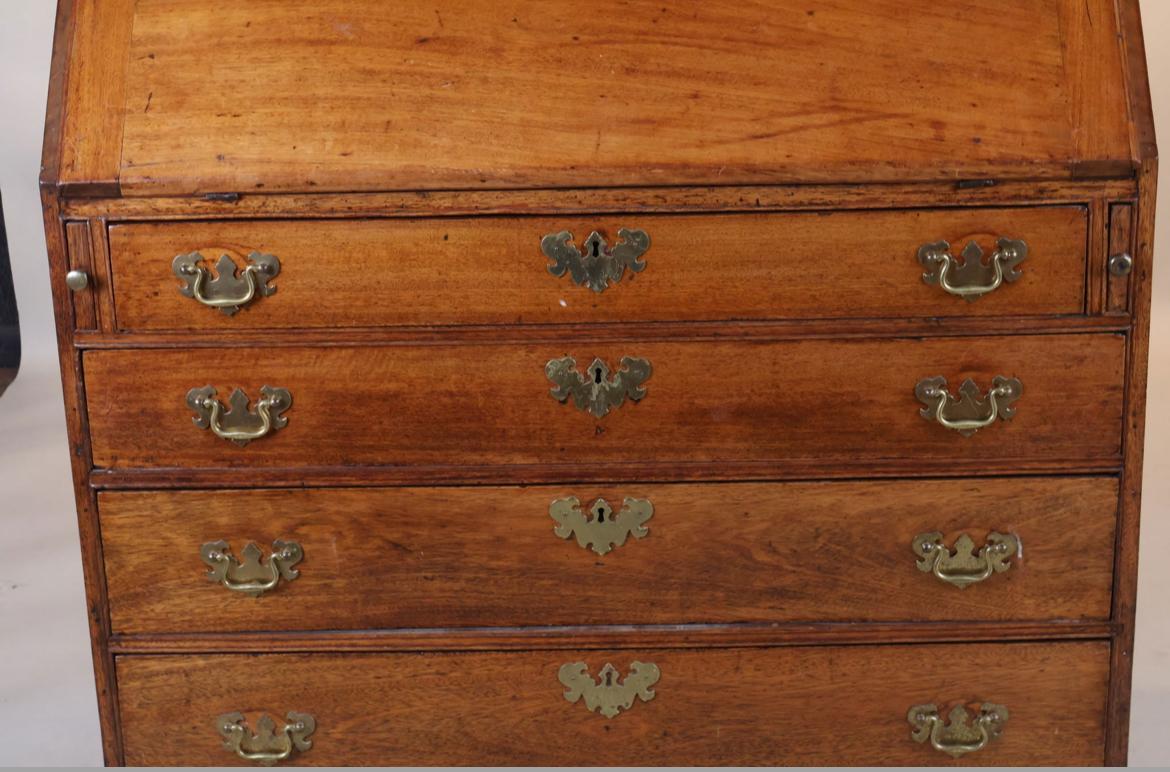 Schrägfrontschreibtisch aus der Föderationszeit mit Inneneinrichtung über einer Bank mit 4 Schubladen auf Konsolenfüßen, aus Kirsche und Mahagoni, um 1790.