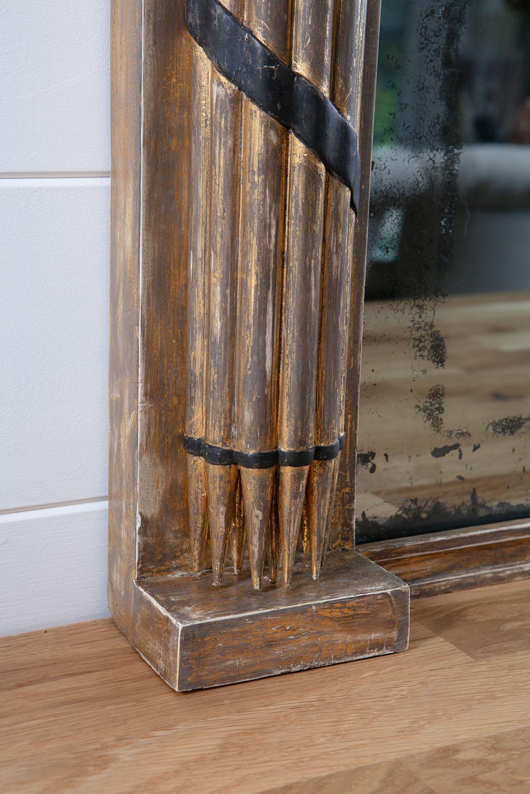 Fine Regency period gilt and ebonised overmantle mirror in the classical Federal taste; the original mirror plate with aged shadowy silvering, in a frame with an ebonised decorative motifs including lions, a central eagle, flanked by columns made of