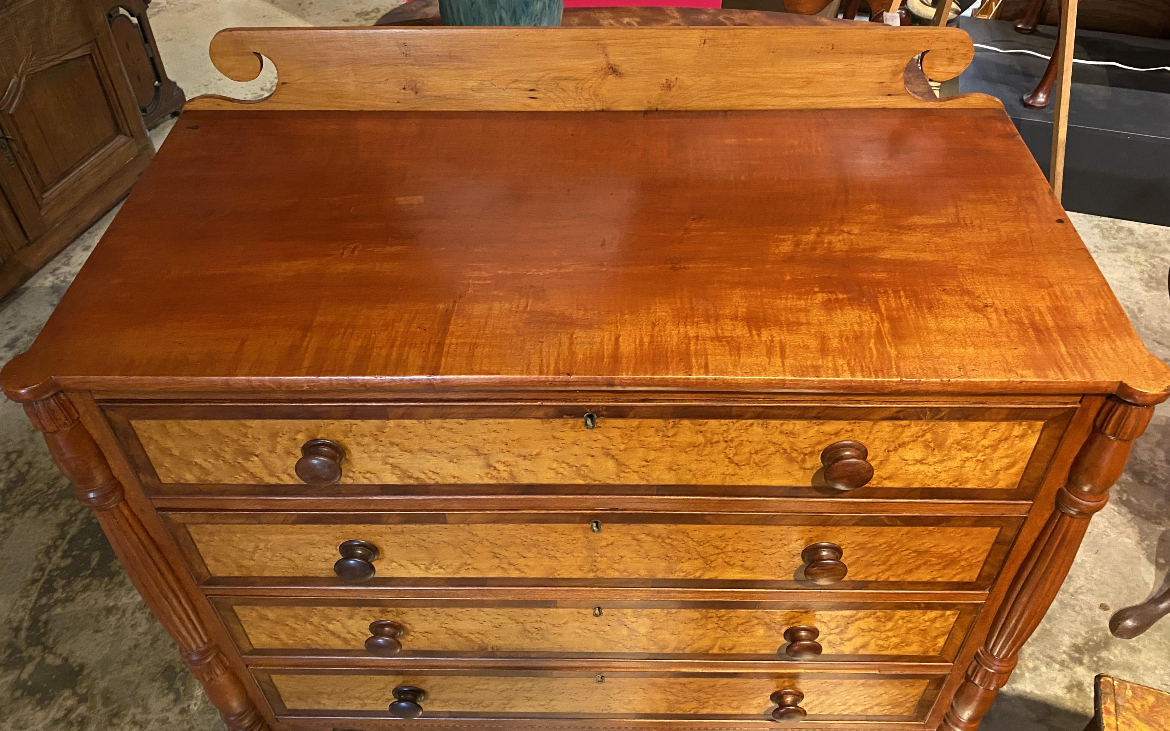 A fine example of a Federal Sheraton four drawer chest with carved backsplash, turret corners,  birdseye maple veneer drawer fronts with mahogany borders, cockbeading, carved corner columns and reeded back corners, and a nicely shaped skirt with