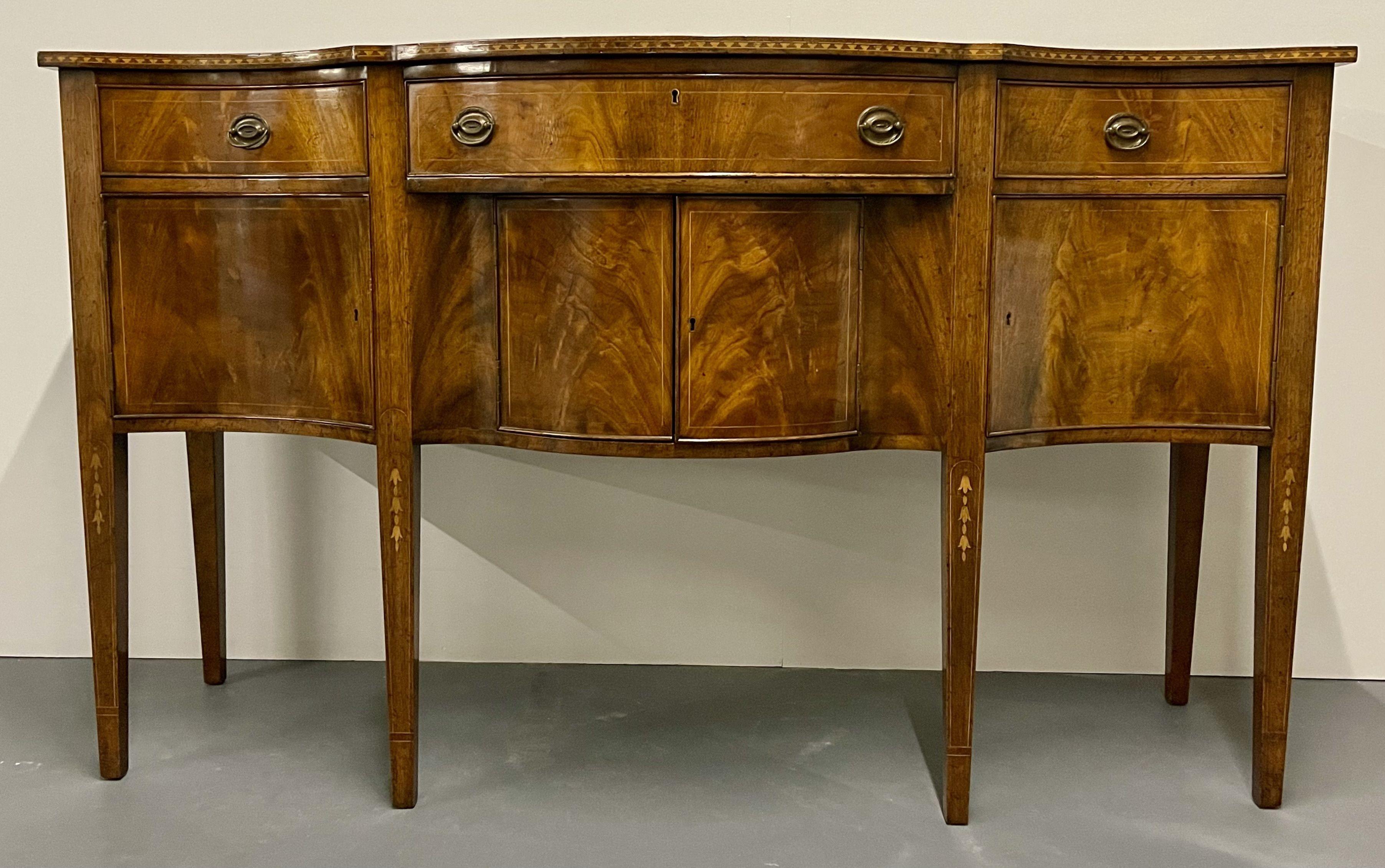 A Federal Sideboard late 19th Early 20th Century. This finely detailed inlaid sold mahogany sideboard has a magnificent flame mahogany finish with all over inlays of bellflower and line design of serpentine shape.

H 39