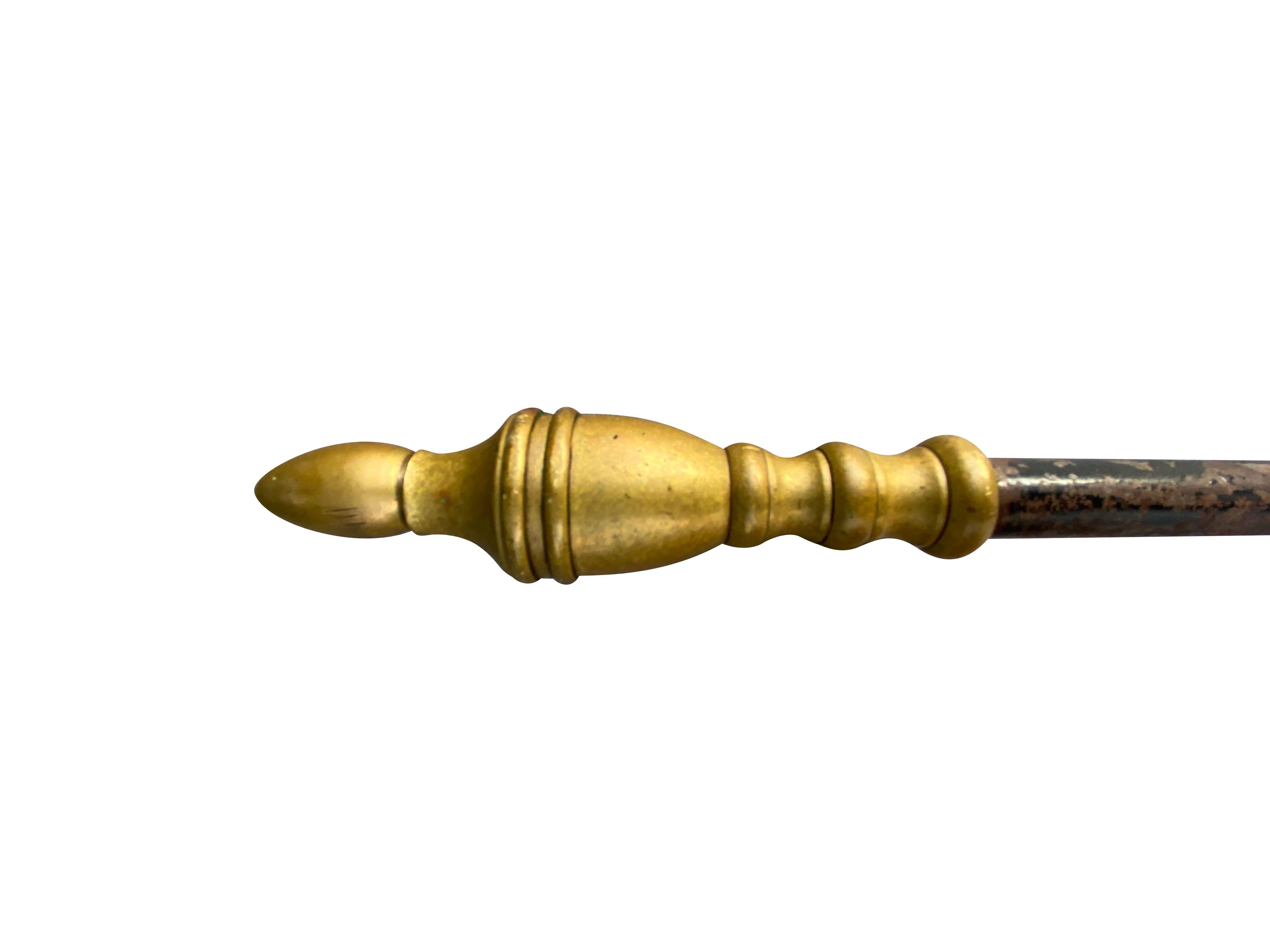 With urn form brass finial and iron shaft ending with trident fork.
