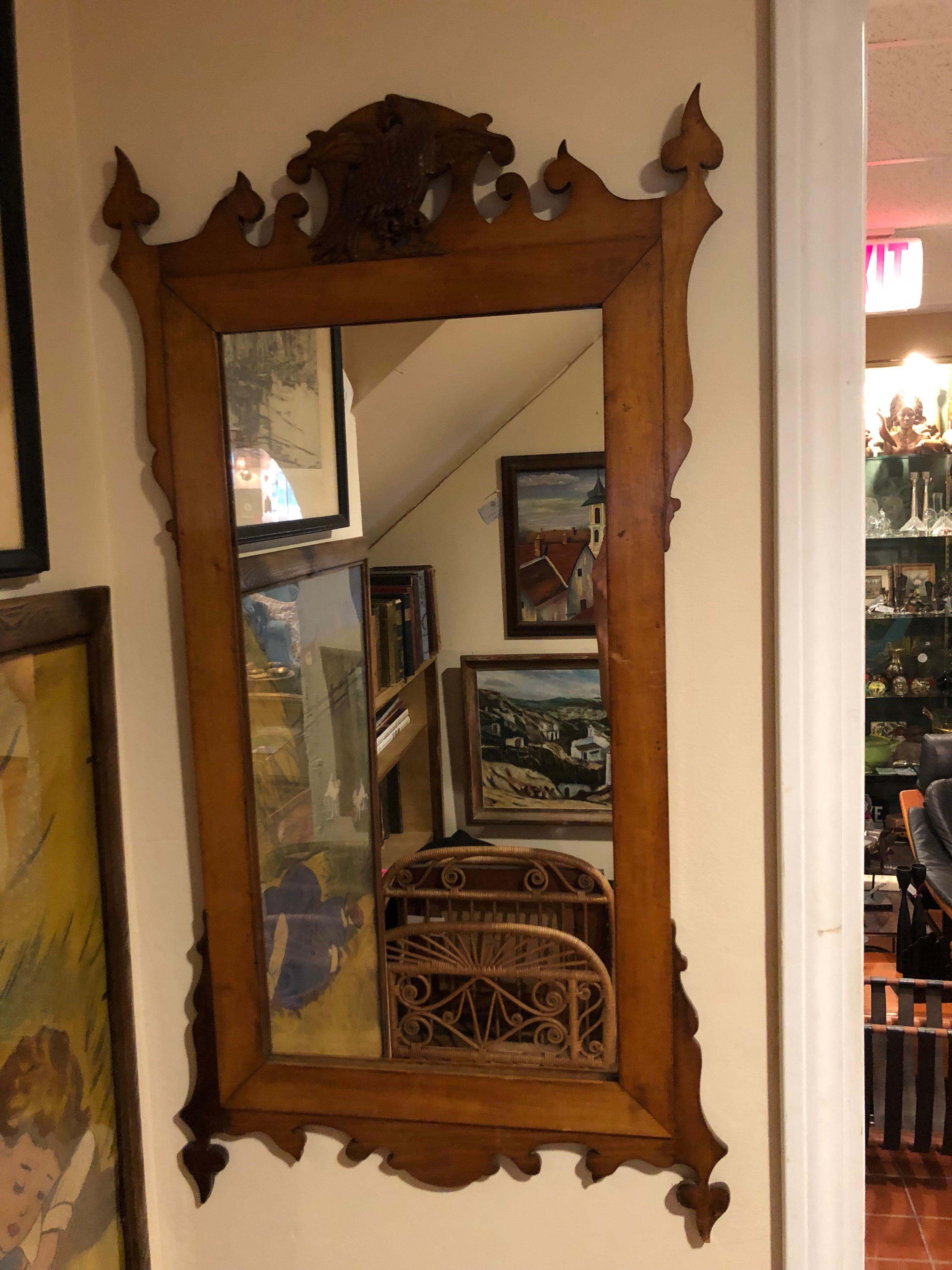 Federal carved wooden mirror with eagle perfect for a narrow hallway or a small bathroom. Made of carved maple wood with a two toned finish. Some pieces of wood are darker and some lighter which makes a nice contrast. Unusual lines make up this fun