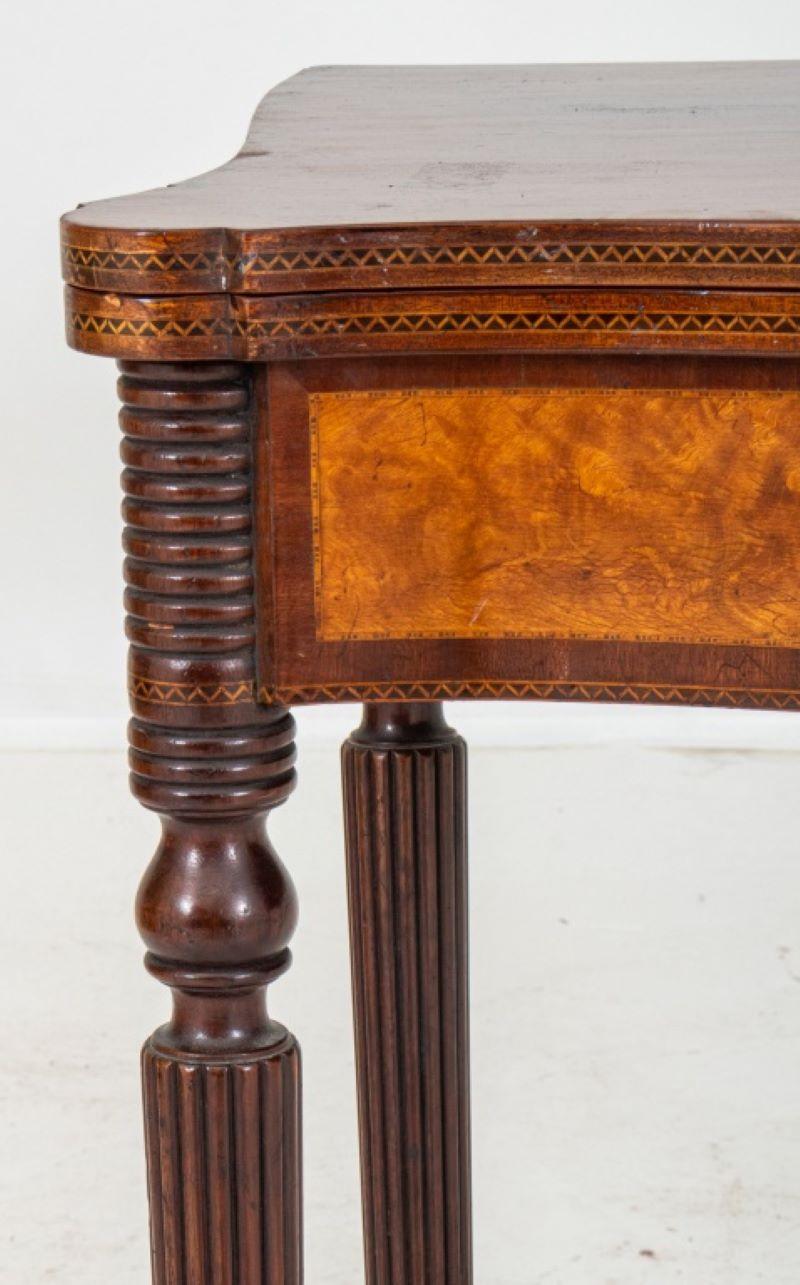 Federal style gate-leg games table, the shaped top above a serpentine inlaid front with burlwood inlay, the whole above turned reeded tapering legs. 29.75