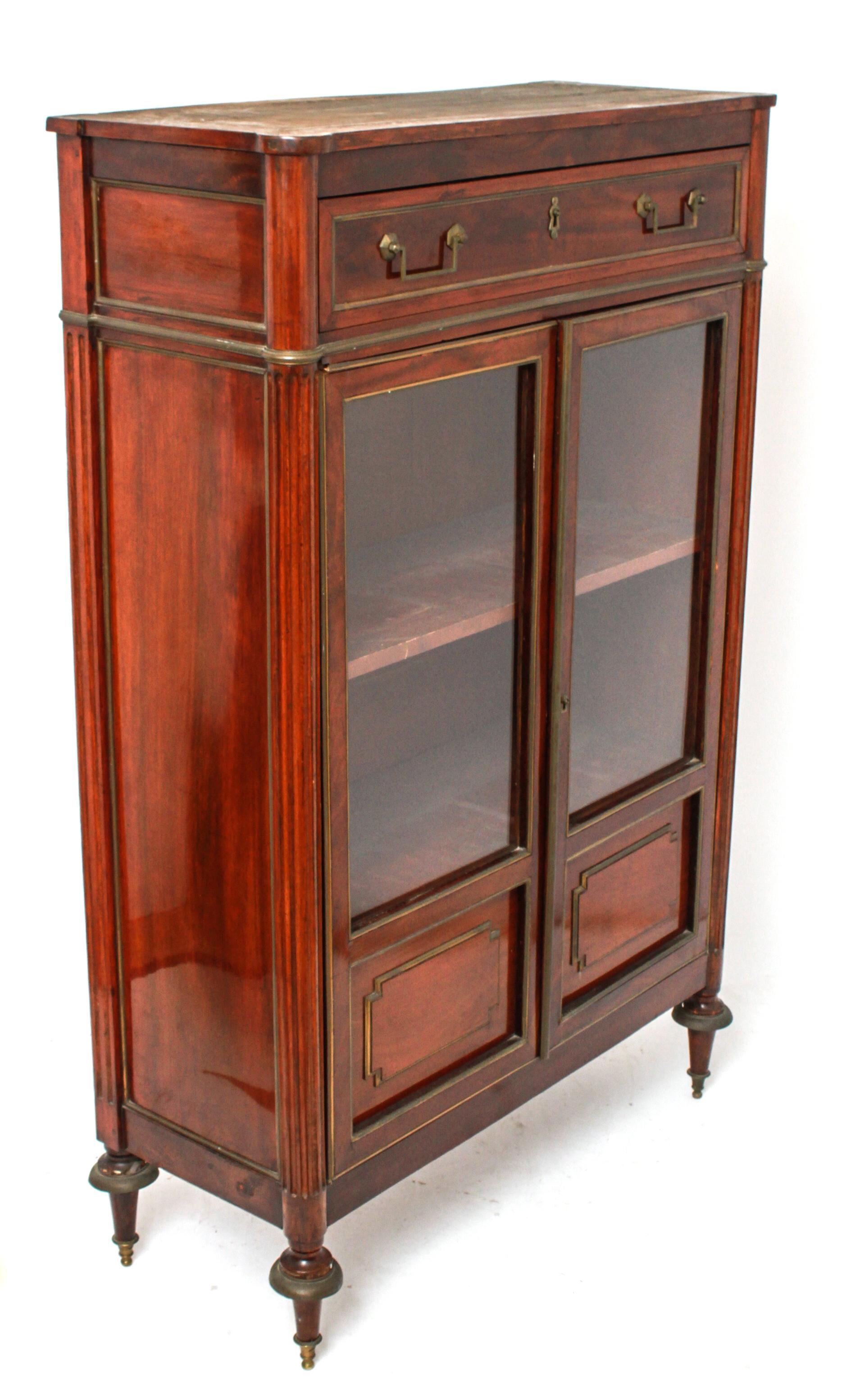 Federal style mahogany cabinet with an Italian gray marble fitted top. The piece has a single drawer over two glass doors flanked by fluted columns and tapered peg legs. Brass mount moldings. In great antique condition with age-appropriate wear and