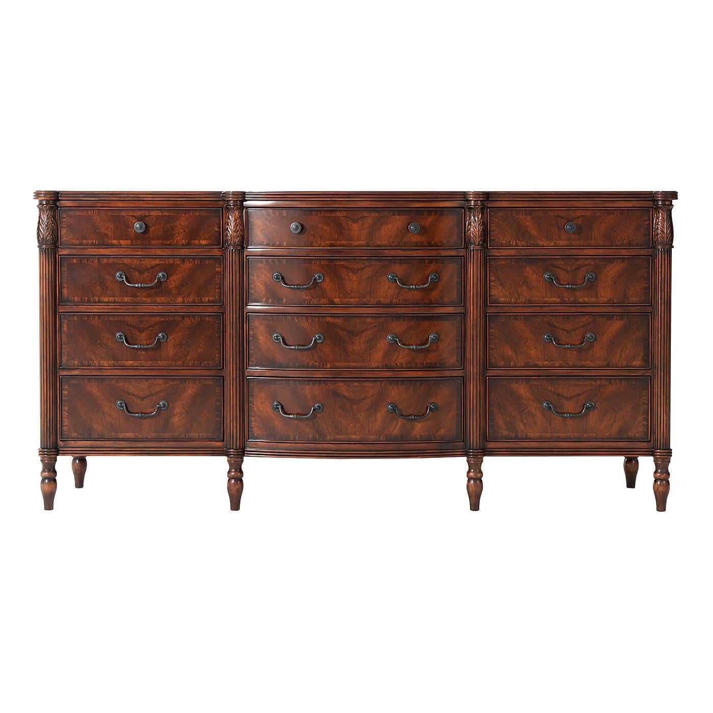 A mahogany and figured mahogany veneered dresser, the reeded edge top with protruding corners and a central bowfront with leaf carved and reeded uprights with three frieze drawers and nine further graduated and crossbanded drawers with verdigris