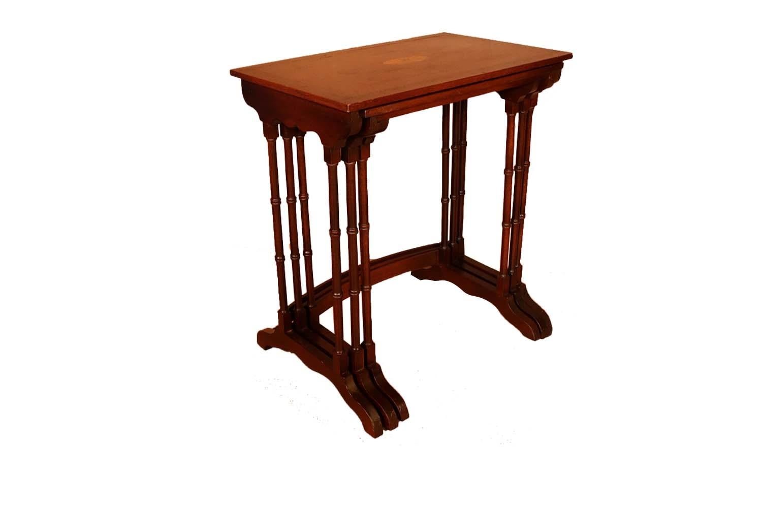 An elegant Federal style mahogany and satinwood trio of nesting tables. This rare, attractive set features a mahogany veneer top framed in a satinwood and ebony stringer with a centered satinwood fan medallion. The lovely top rests on a scalloped