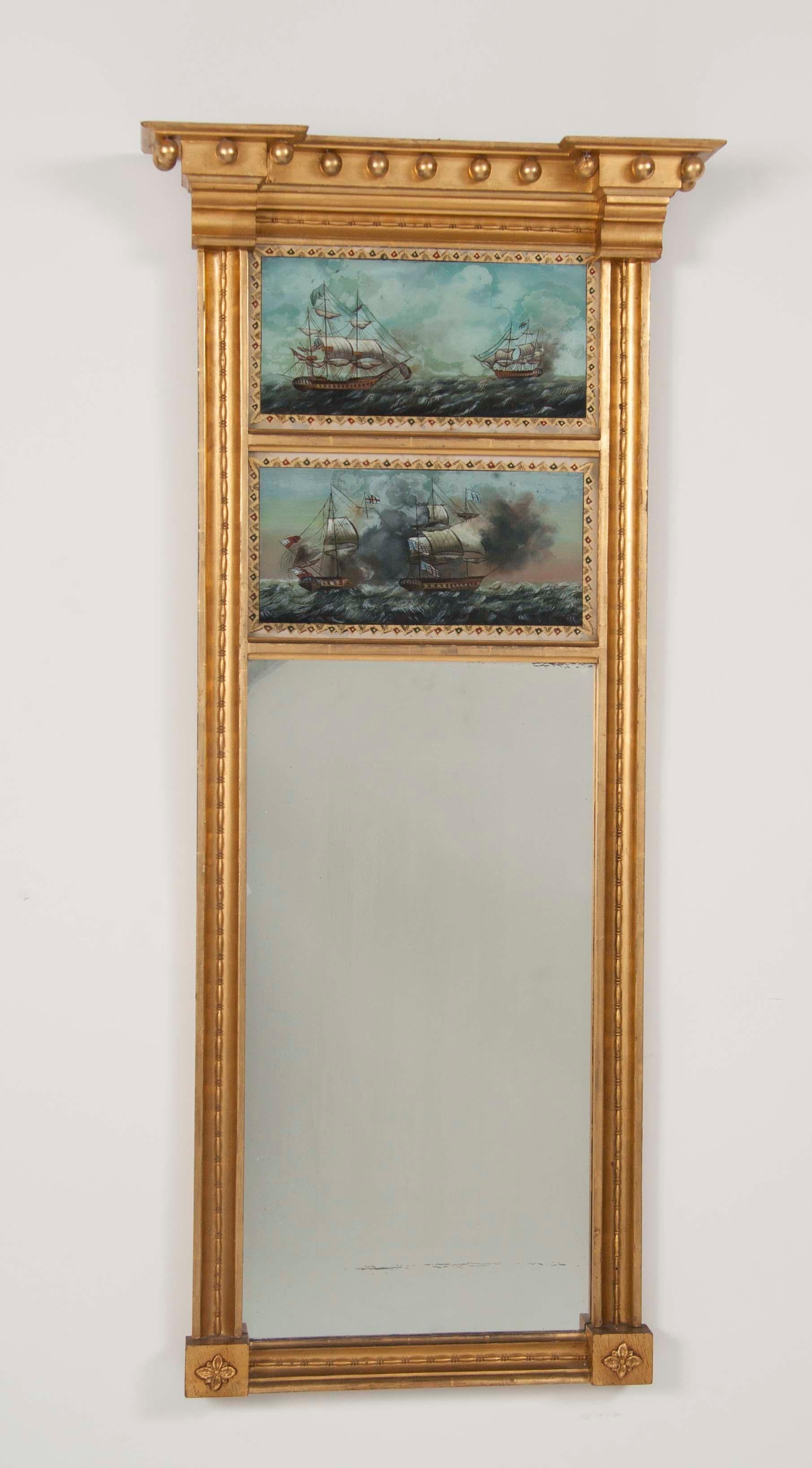 A beautifully giltwood Federal style mirror featuring églomisé scenes of the USS Constitution and HMS Guerriere, a famous early naval battle in the war of 1812 won by USS Constitution and frequently honored in these mirror panels.

FW 1162.