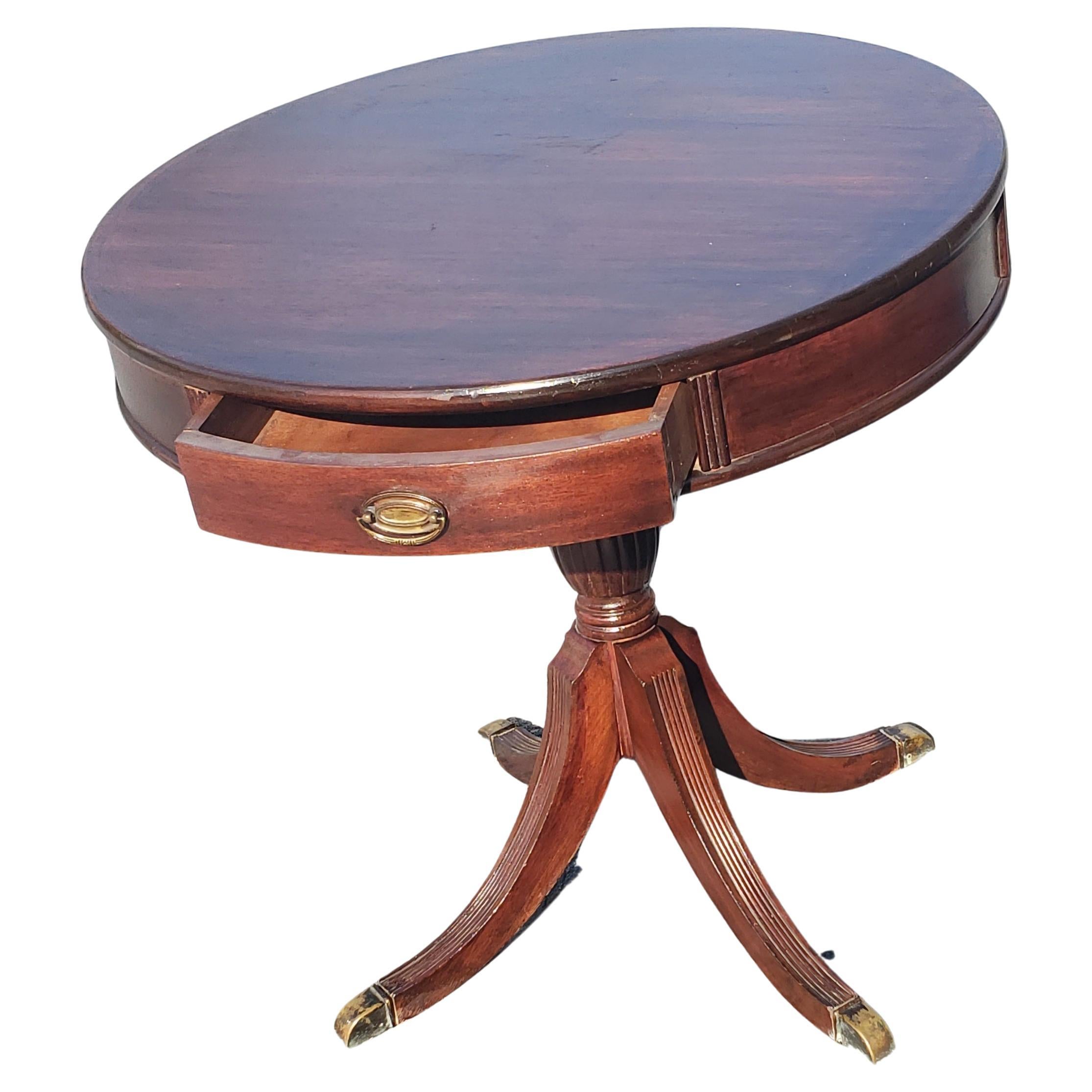 This vintage mahogany drum table was crafted in the US around the year 1940. The mahogany looks incredible, with a rich complexion that is framed beautifully by an array of details. The turned pedestal base was crafted in a traditional Georgian