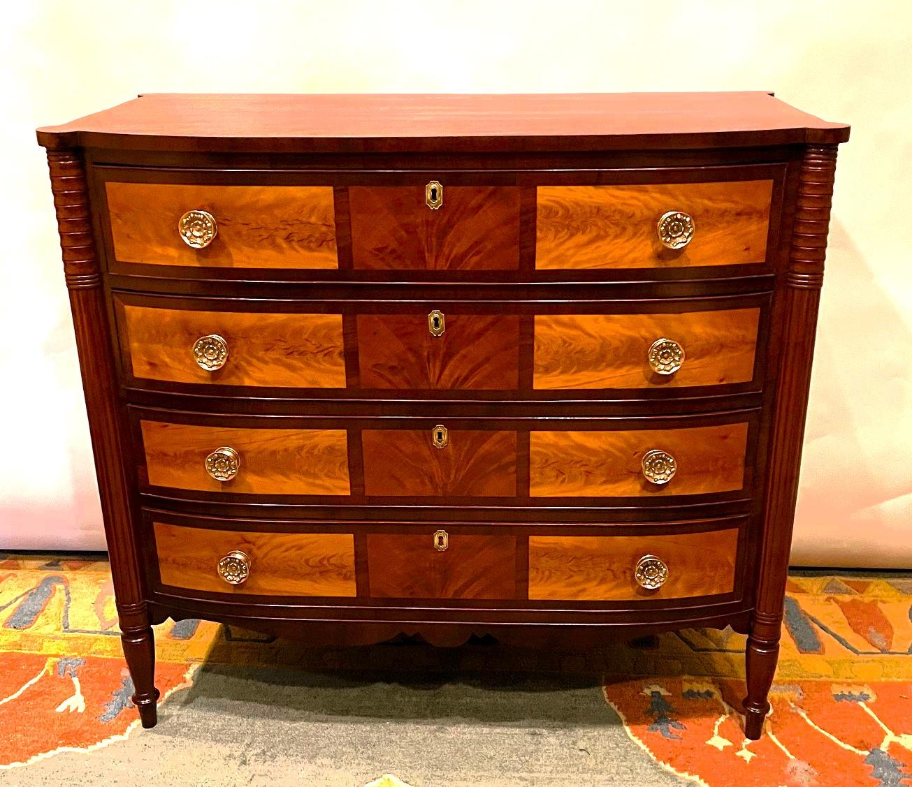 This Sheraton inspired  chest is indicative of the work done by cabinet makers in and around Portsmouth, New Hampshire in the late 18th and early 19th Centuries. The stunning look of this piece is created by the combination of woods used on the