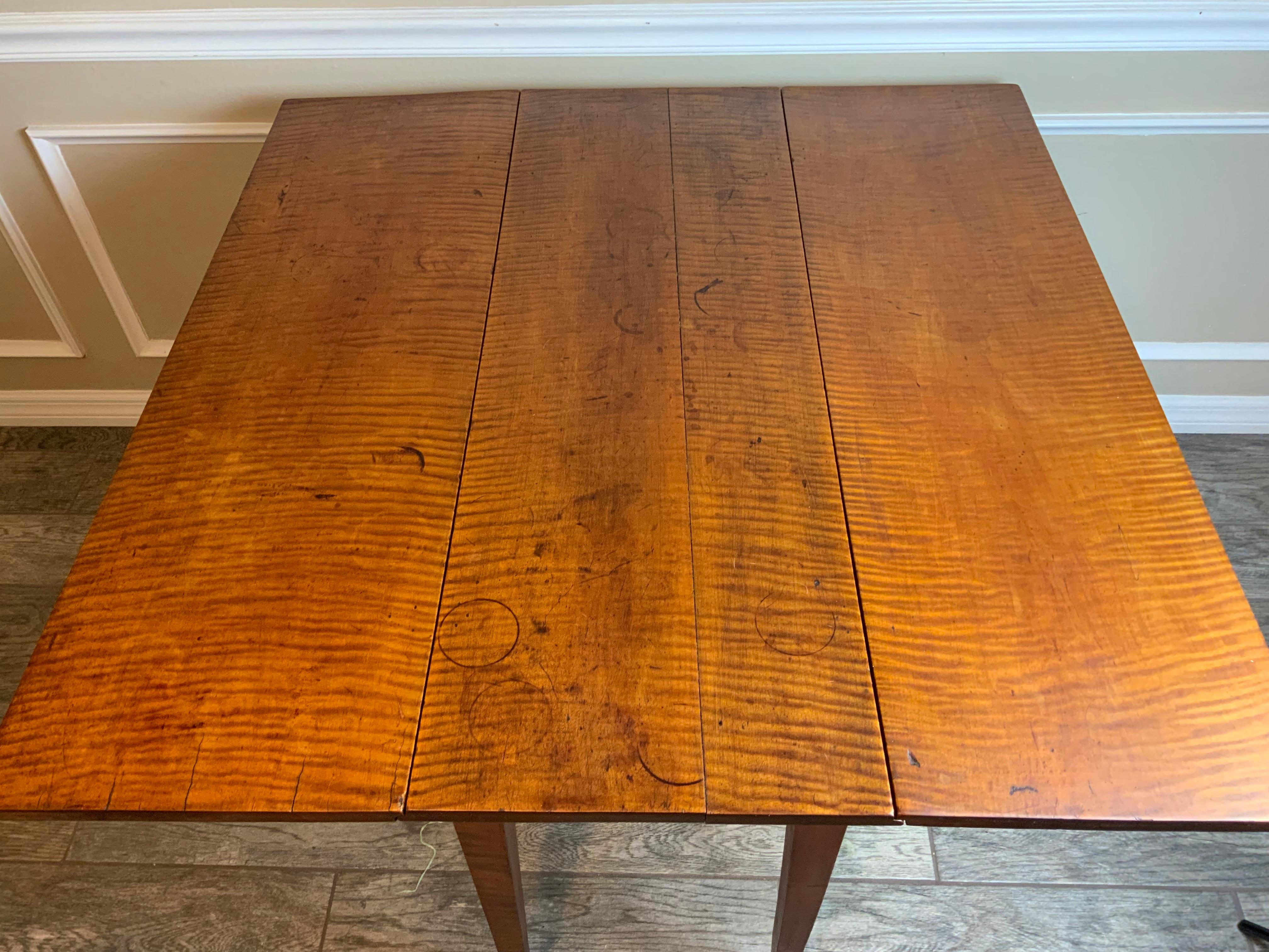 Nicely figured Federal curly Maple table 1790-1815 with tapered splayed legs. This is a very clean table in great condition with an old refinish exhibiting great color and patina. The total width with the leaves up is 41.25.

Condition: Very good