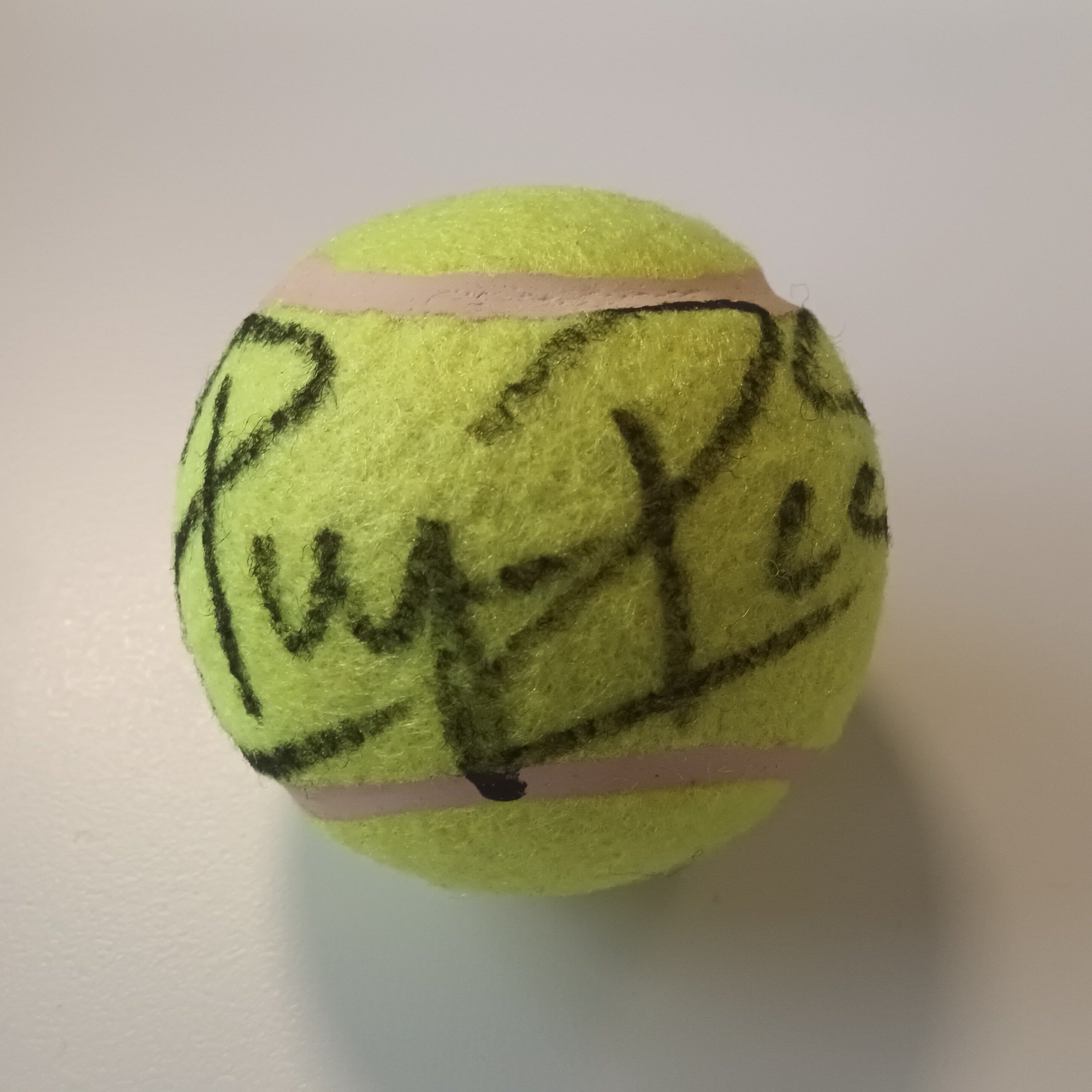 A trio of regular-size tennis balls, signed separately by the 