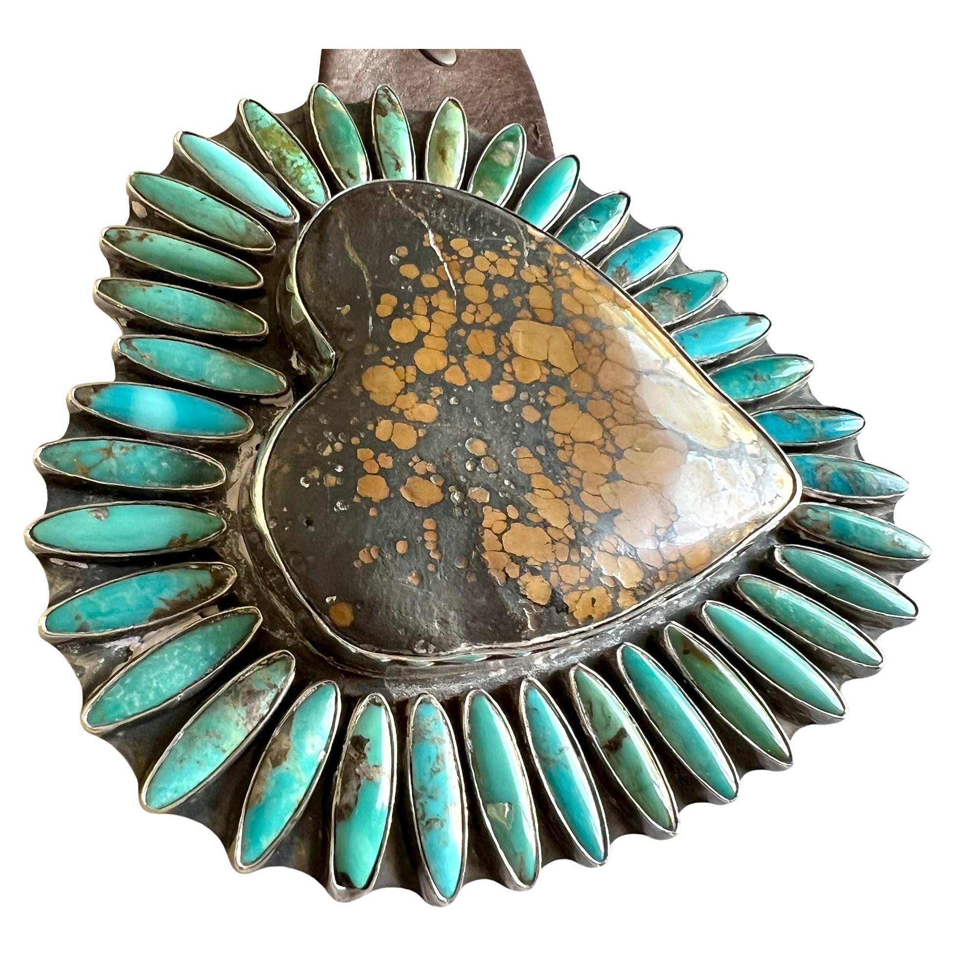 Incredible heart shaped belt buckle featuring a large natural earth brown giraffe turquoise surrounded by thirty six marquis shaped blue turquoise. Buckle measures 5