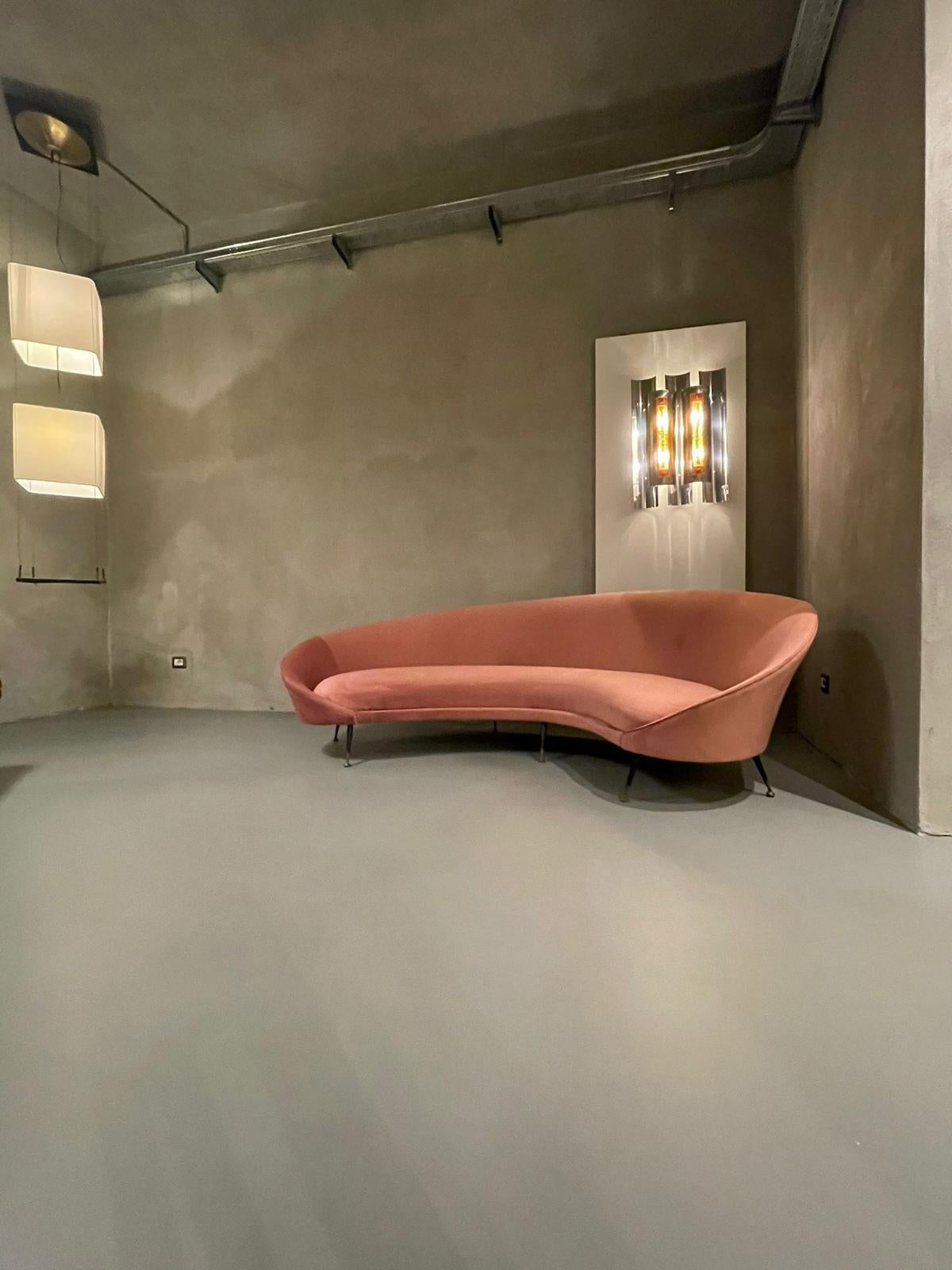 Federico Munari sofa manufactured in Italy, 1951.
Charming curved shape sofa, upholstered in pink velvet on seven legs with brass feet tips. 
Excellent vintage patina.
 