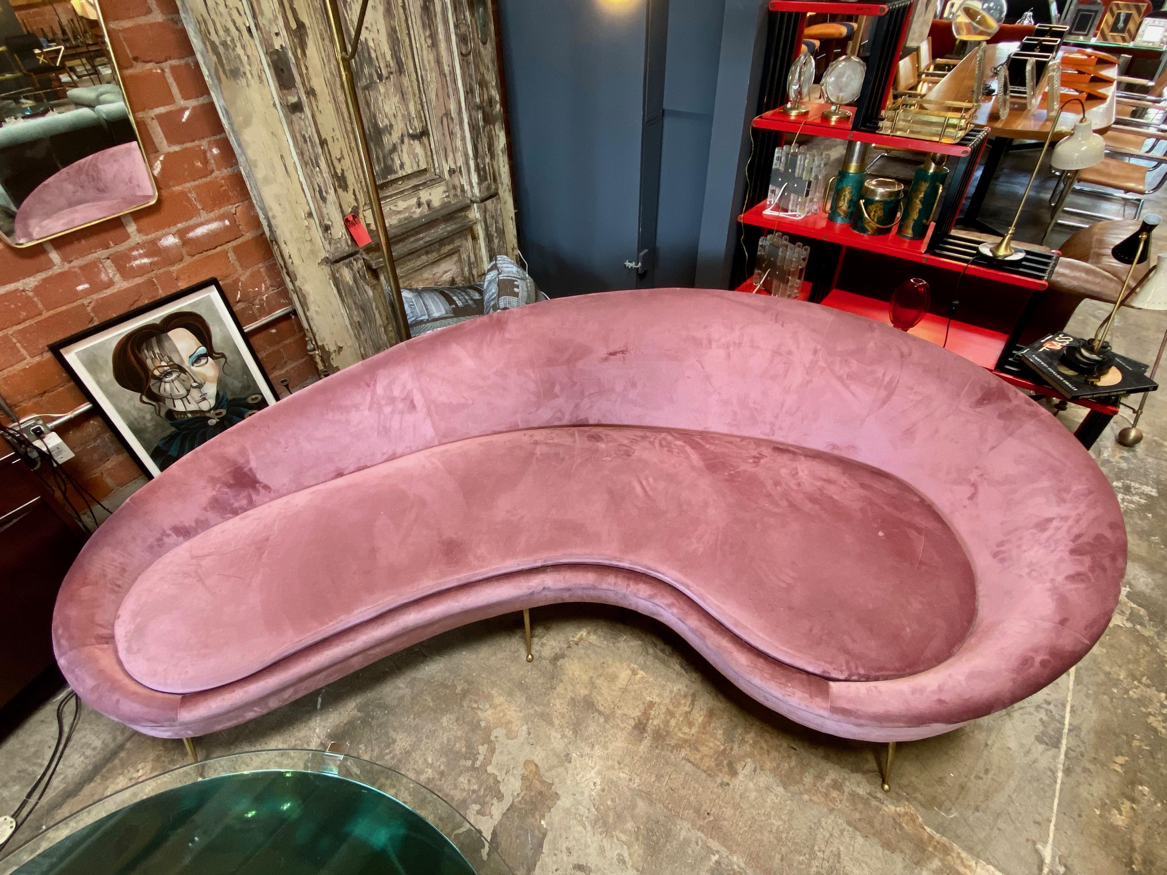 Italian pale pink blush velvet upholstered sofa with brass legs in the style of Federico Munari. The curving form allows it to be placed in many room configurations as it looks good from the back as well as the front.