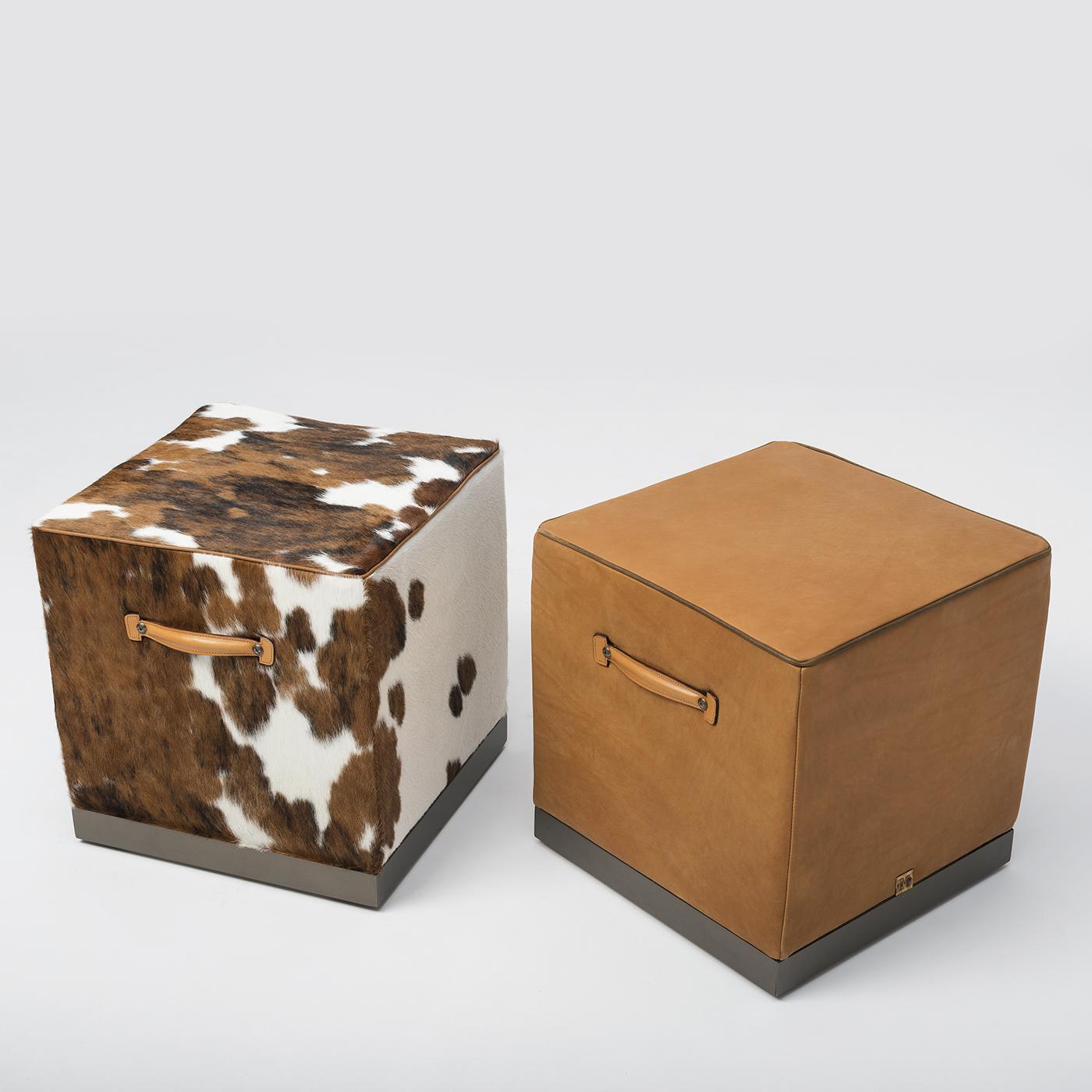 The Fedro Pouf adds a playful touch to any living space. Its cubic silhouette exudes a simple elegance, supported by a robust internal structure. Finished with swivel wheels inserted into the base and leather handles on the sides for maximum