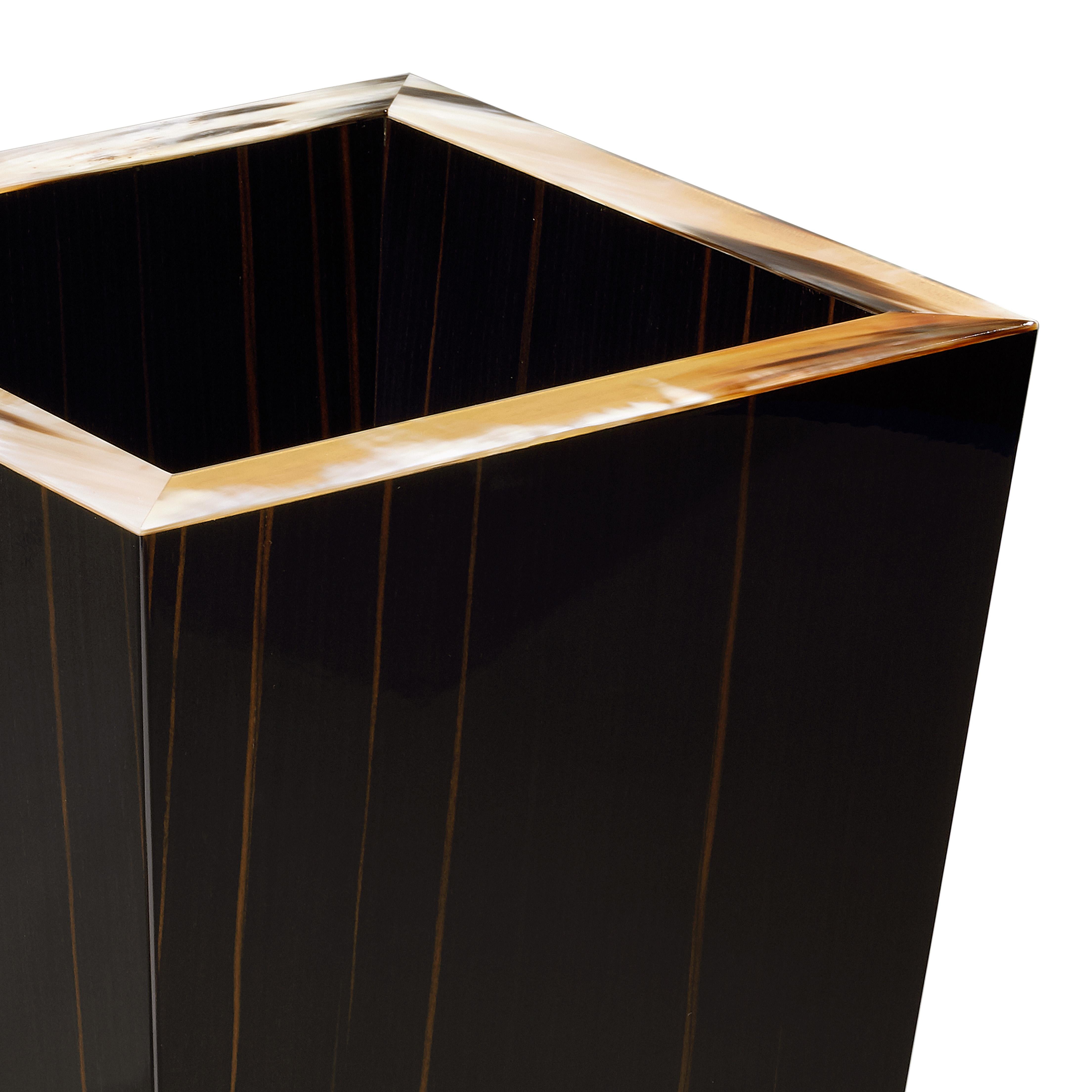 Add a stroke of sophistication to a home or office space with Fedro waste paper basket. Crafted from glossy ebony, the inverted pyramidal structure is enriched by an elegant rim in brown veined Corno Italiano. Standing upon four tiny feet in 24kgold