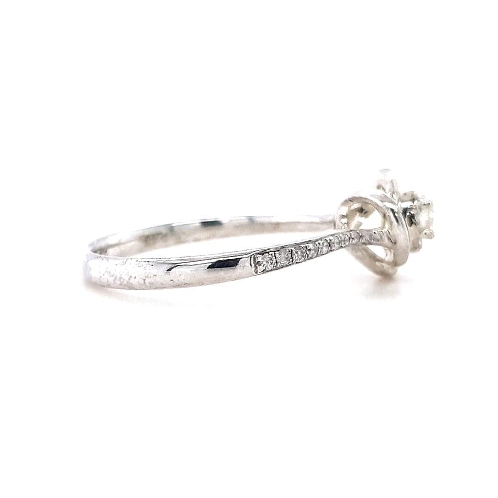 The exquisite Aurora Engagement Ring features a dazzling centre 0.112ct diamond, elegantly set within a concertina setting and encircled by a twisted halo of gold. The shoulders of the ring cascade with diamonds, all set in lustrous 9ct white gold.