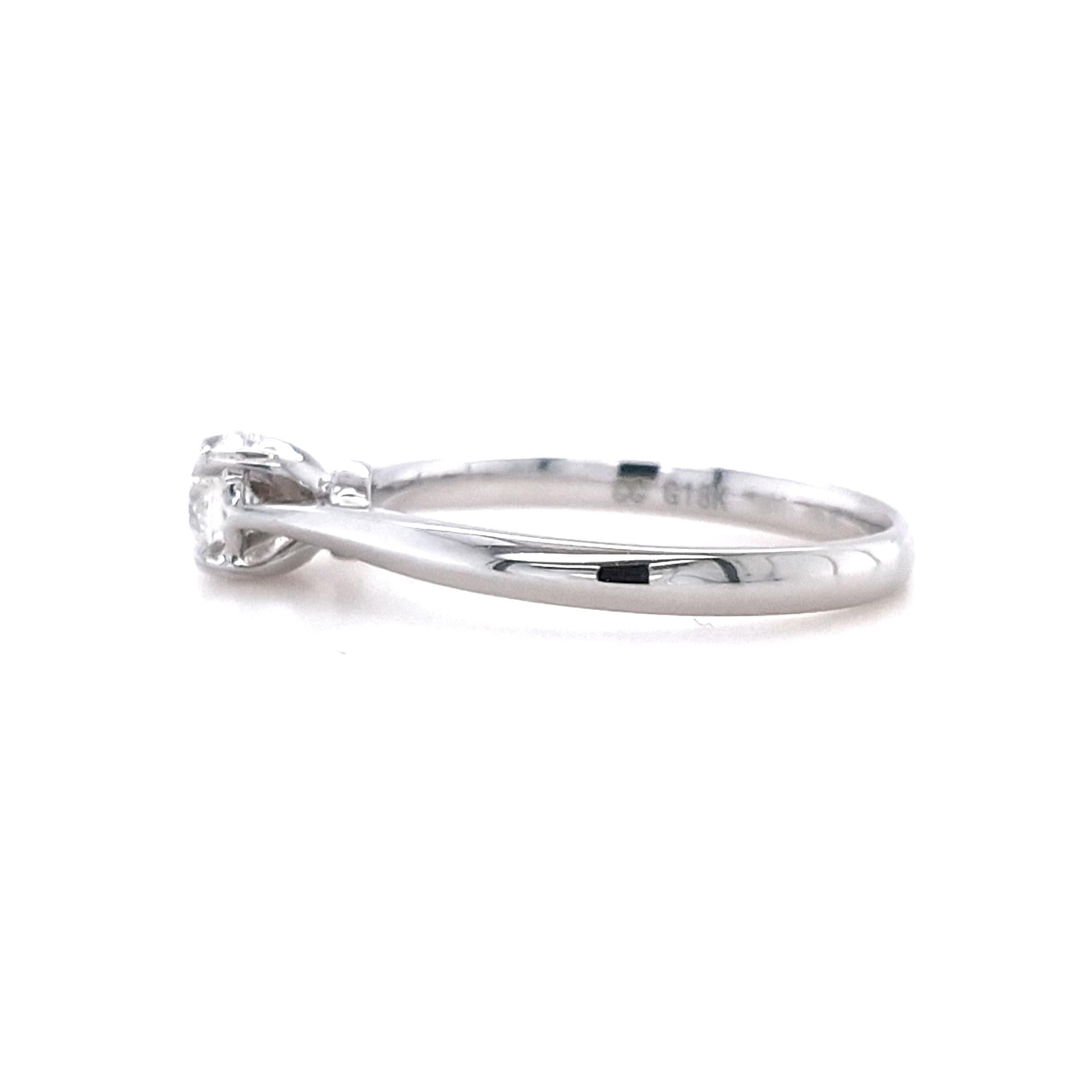 Ammira l'epitome dell'eleganza e della raffinatezza con questo squisito anello con solitario di diamanti in oro bianco 18 ct. Meticolosamente realizzata, la montatura decorativa scanalata aggiunge un tocco di opulenza, elevando questo gioiello a