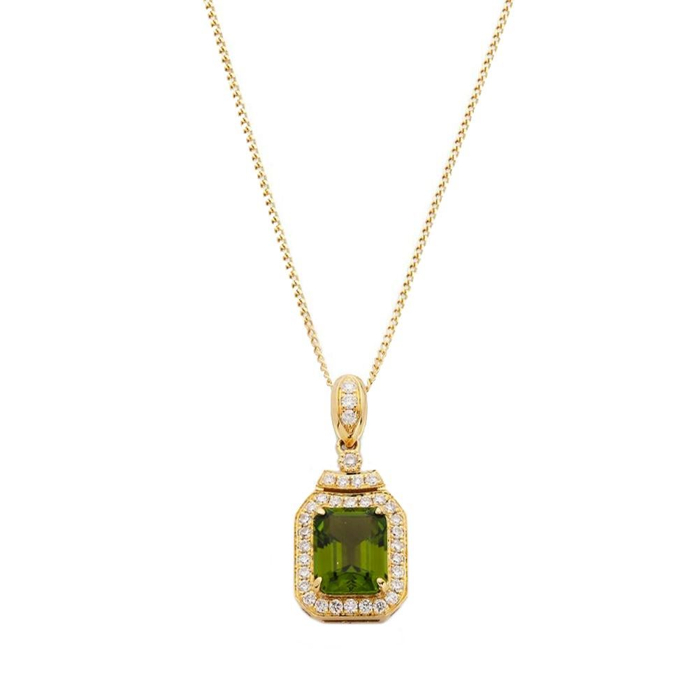 An exquisite 18ct yellow gold pendant, featuring a step-cut 1.06ct green tourmaline pendant, adorned with a dazzling diamond halo and bail. The total weight of diamonds is approximately 0.174ct. This dainty piece effortlessly suspends from an