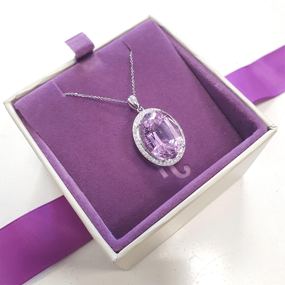 This exquisite 18ct gold pendant epitomises luxury and elegance, showcasing a stunning 17.60ct oval-cut kunzite at its heart. The kunzite's delicate blush-pink hue is both captivating and rare, exuding a soft yet radiant allure that is simply