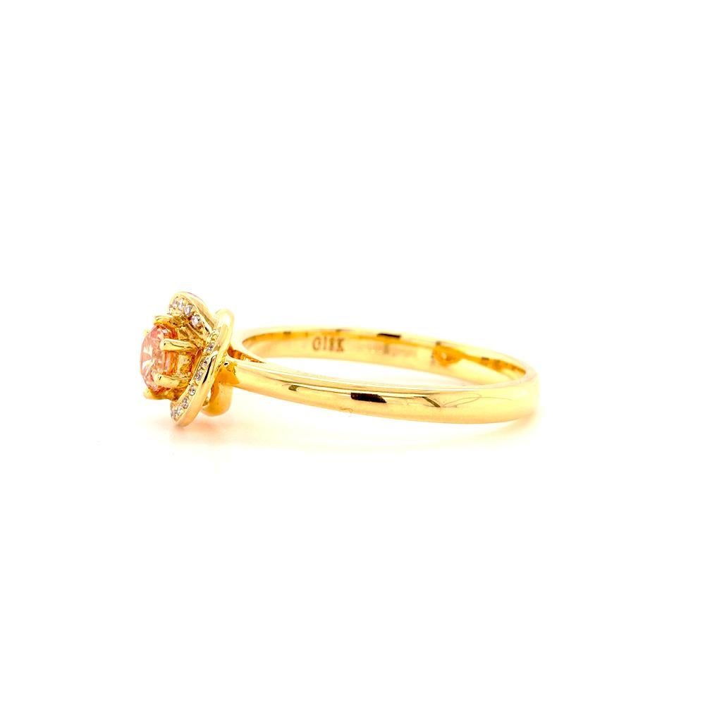 The exquisite Aurora Engagement Ring showcases a stunning 0.25ct pink champagne diamond, elegantly framed by a twisted halo of diamonds, set in lustrous 18ct yellow gold. Say yes to the celestial allure of this finely crafted ring, designed for that