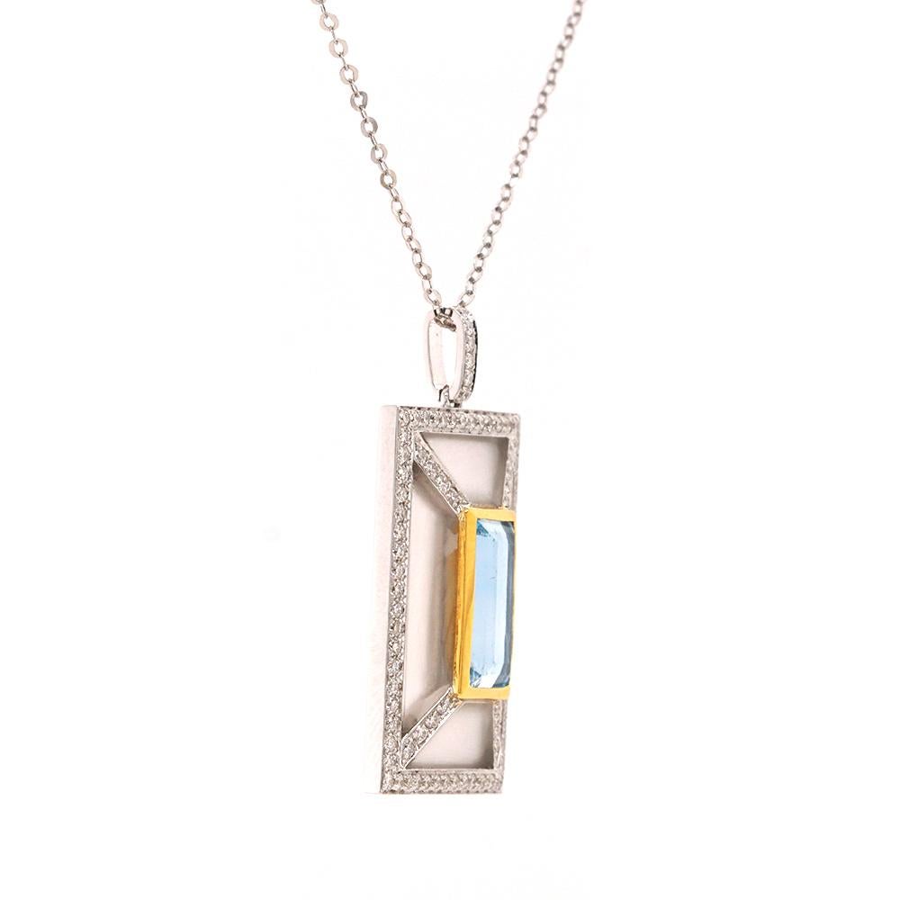 Este exquisito colgante es un impresionante alarde de elegancia y artesanía. Elaborada por expertos en oro blanco de 18 ct, presenta una cautivadora aguamarina engastada en bisel de 1,88 ct, bellamente acentuada con toques de oro amarillo que