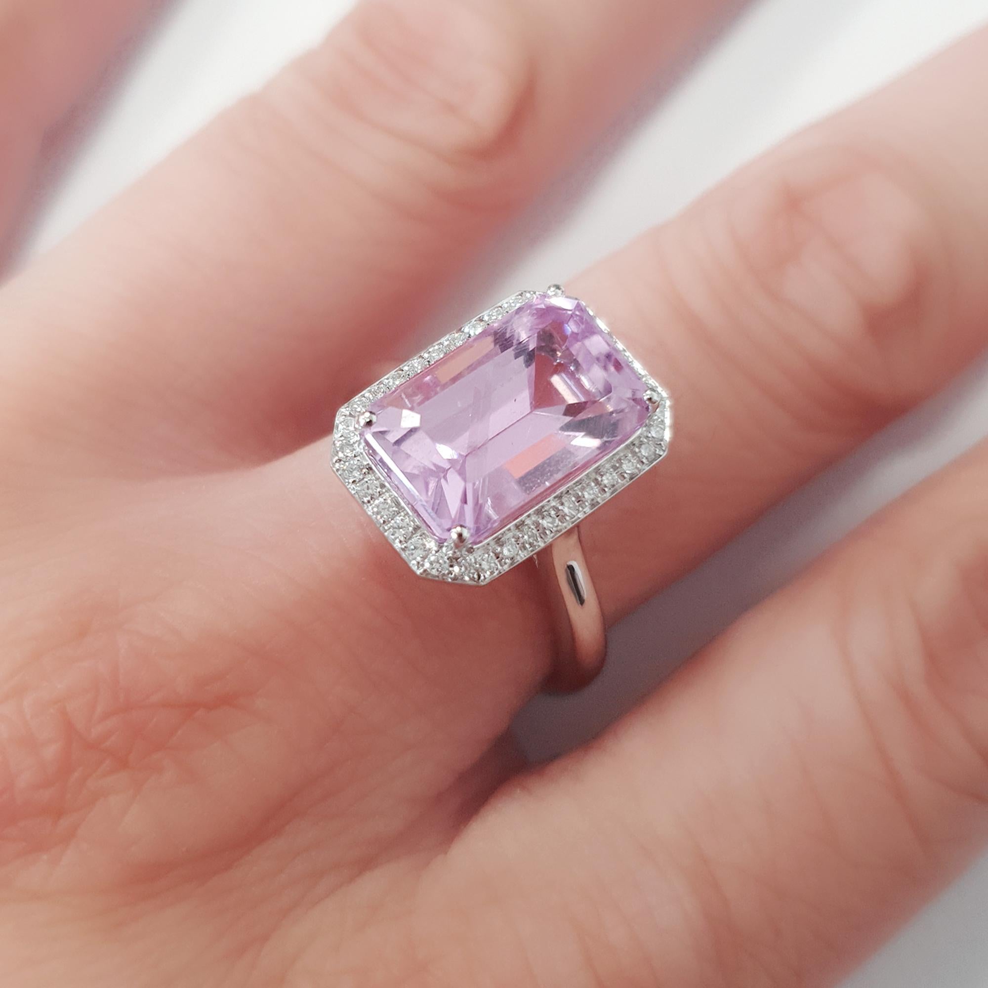 Bathed in a tender blush, this enchanting ring showcases a rectangular-cut kunzite, elegantly framed by a halo of pavé-set diamonds. The soft gleam of the platinum band lends a cool sophistication, allowing the warm tones of the central stone to