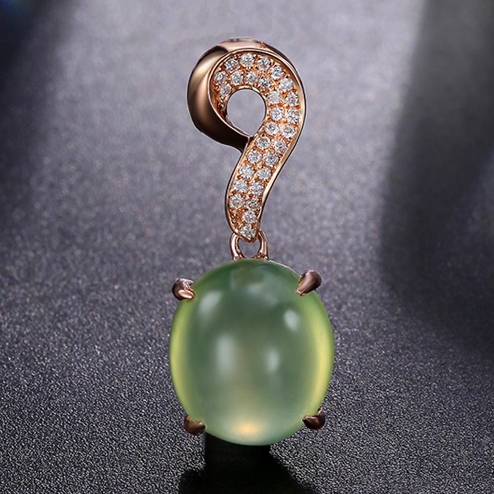 Avec une tension poétique et une asymétrie élégante, ce pendentif associe une préhnite aux tons froids à une gracieuse boucle d'or rose constellée de diamants. La forme interrogative de la caution attire le regard vers l'intérieur, invitant à la