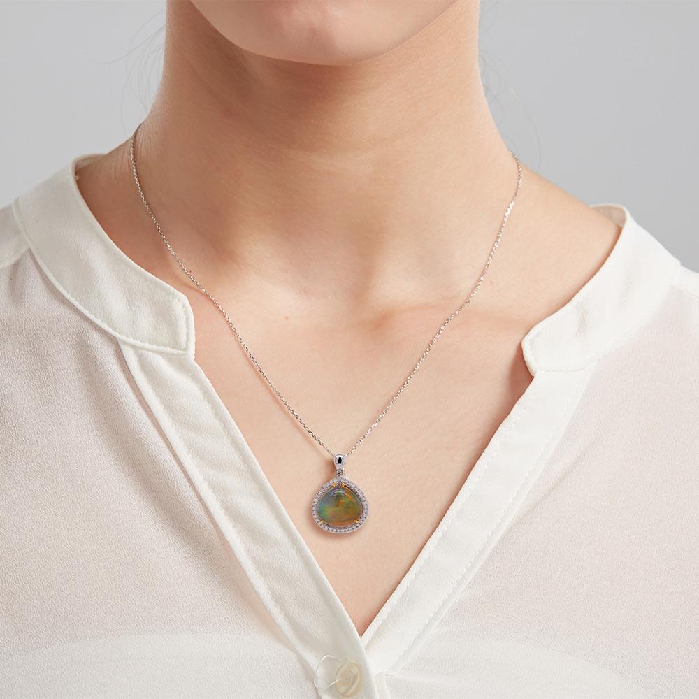 An enchanting chromatic pendant with a touch of classic design. This opal pendant exudes an energy of colour to keep you glowing throughout the day. It features a 6.21ct opal framed with 0.273ct diamonds set in 18ct white gold with yellow