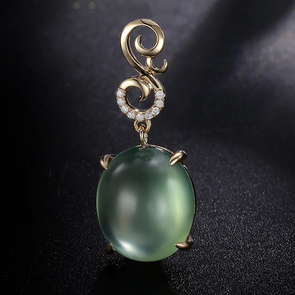 Este colgante, una oda al tranquilo esplendor, presenta una serena prehnita enmarcada por un arco ascendente de diamantes en una fianza esculpida en forma de voluta. El suave tono verde ofrece una claridad tranquilizadora, mientras que la forma de