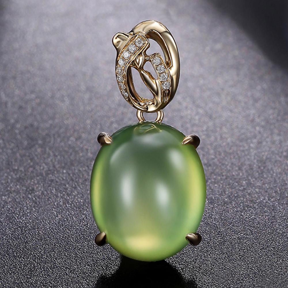 D'une grandeur tranquille, cette suspension équilibre structure et douceur. La caution se dresse comme une couronne d'or, ornée de diamants qui rappellent les épis de faîtage des temples ou les flèches fleuries. En dessous, la prehnite brille d'un